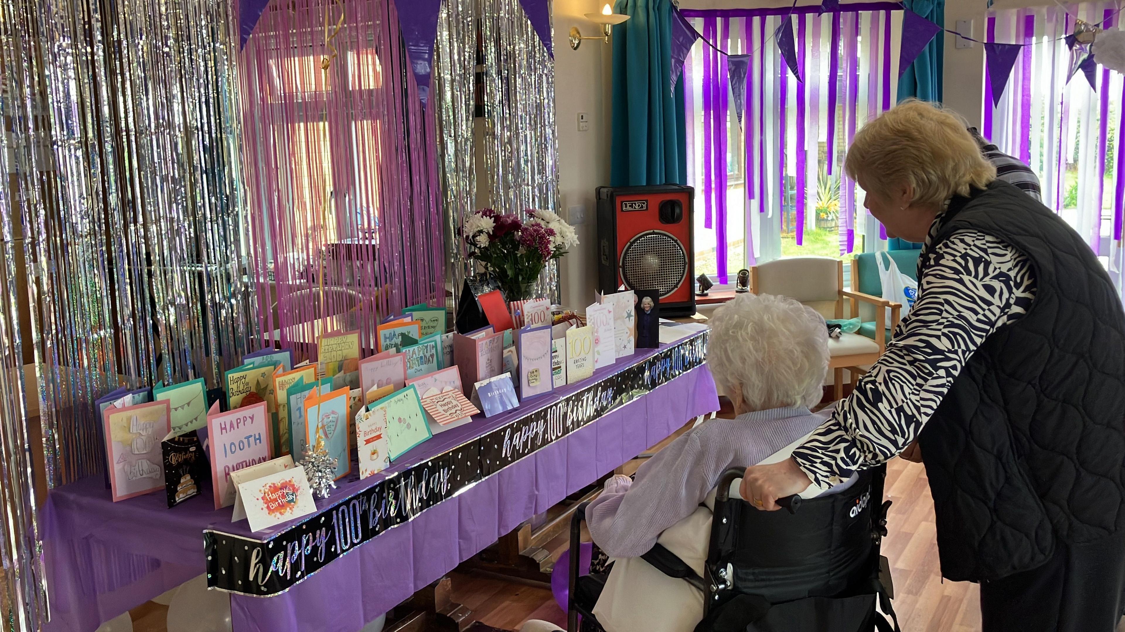 Olive admiring her birthday cards that are on a table