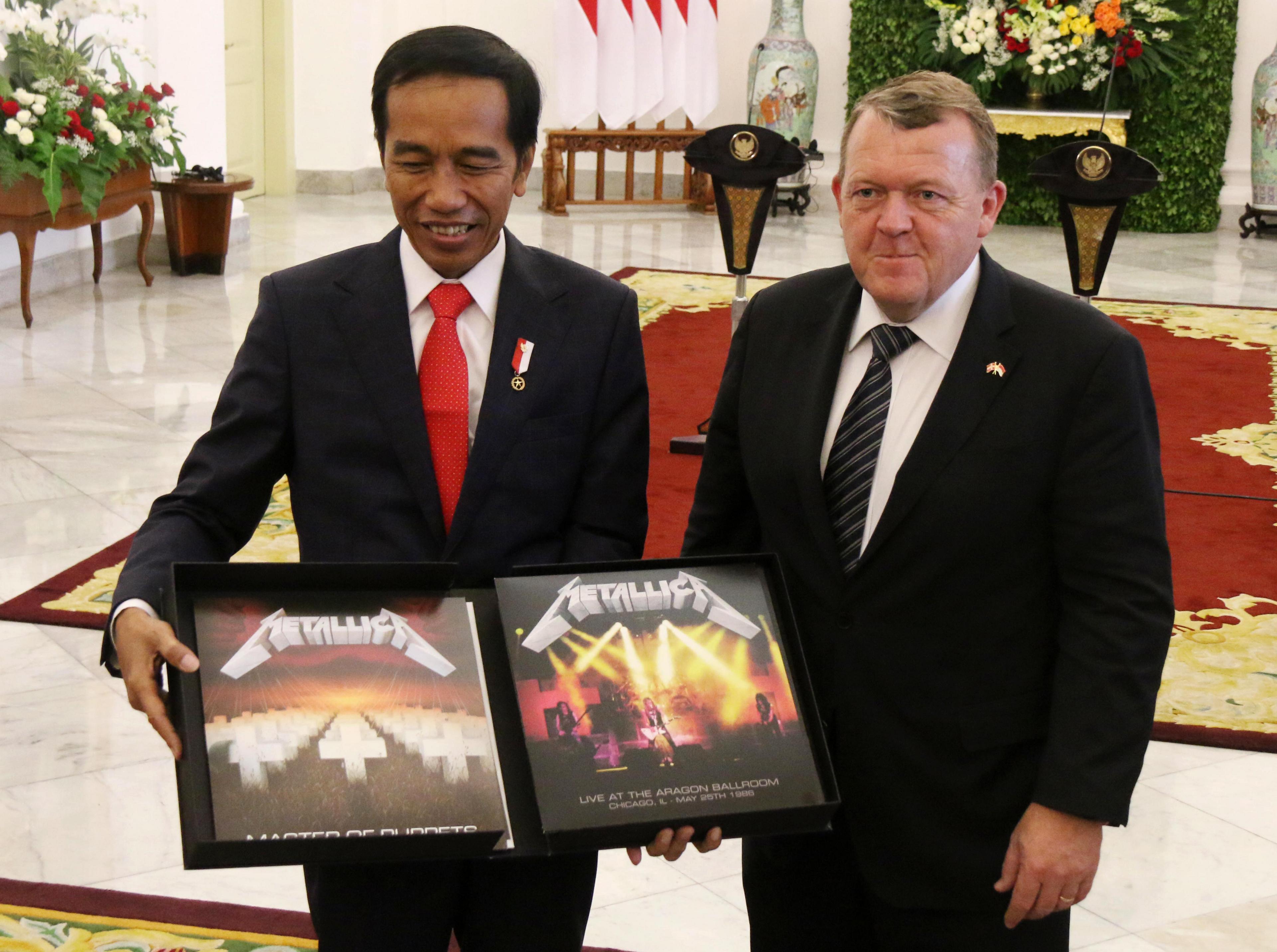 President Joko Widodo shows off the Metallica album from Danish Prime Minister Lars Rasmussen