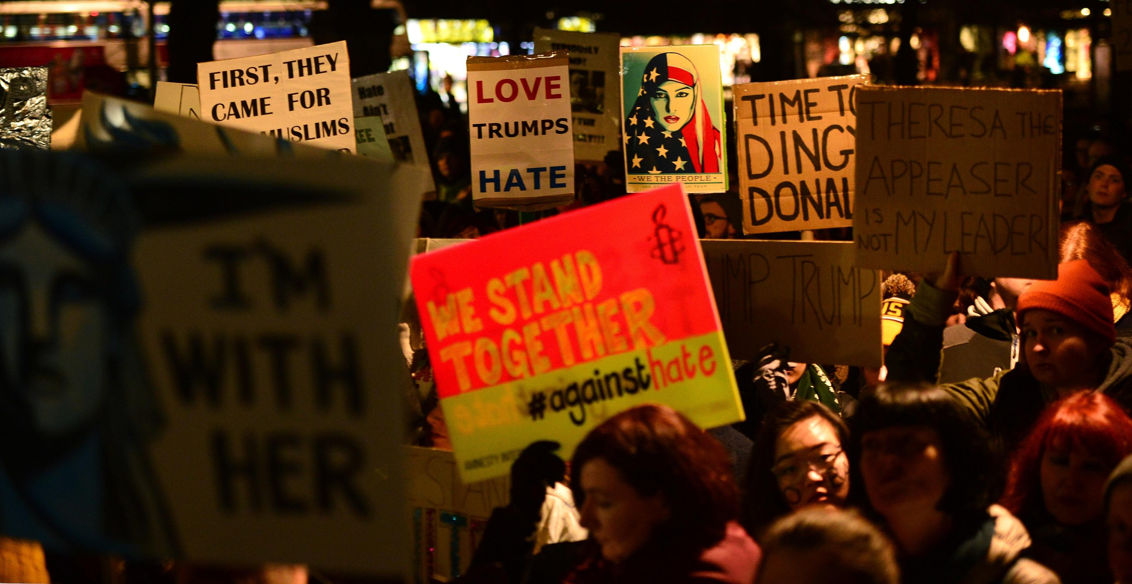 Demonstrators hold placards as they march from the Mound to the Scottish Parliament to protest against President Trump"s Muslim travel ban to the USA on January 30, 2017 in Edinburgh