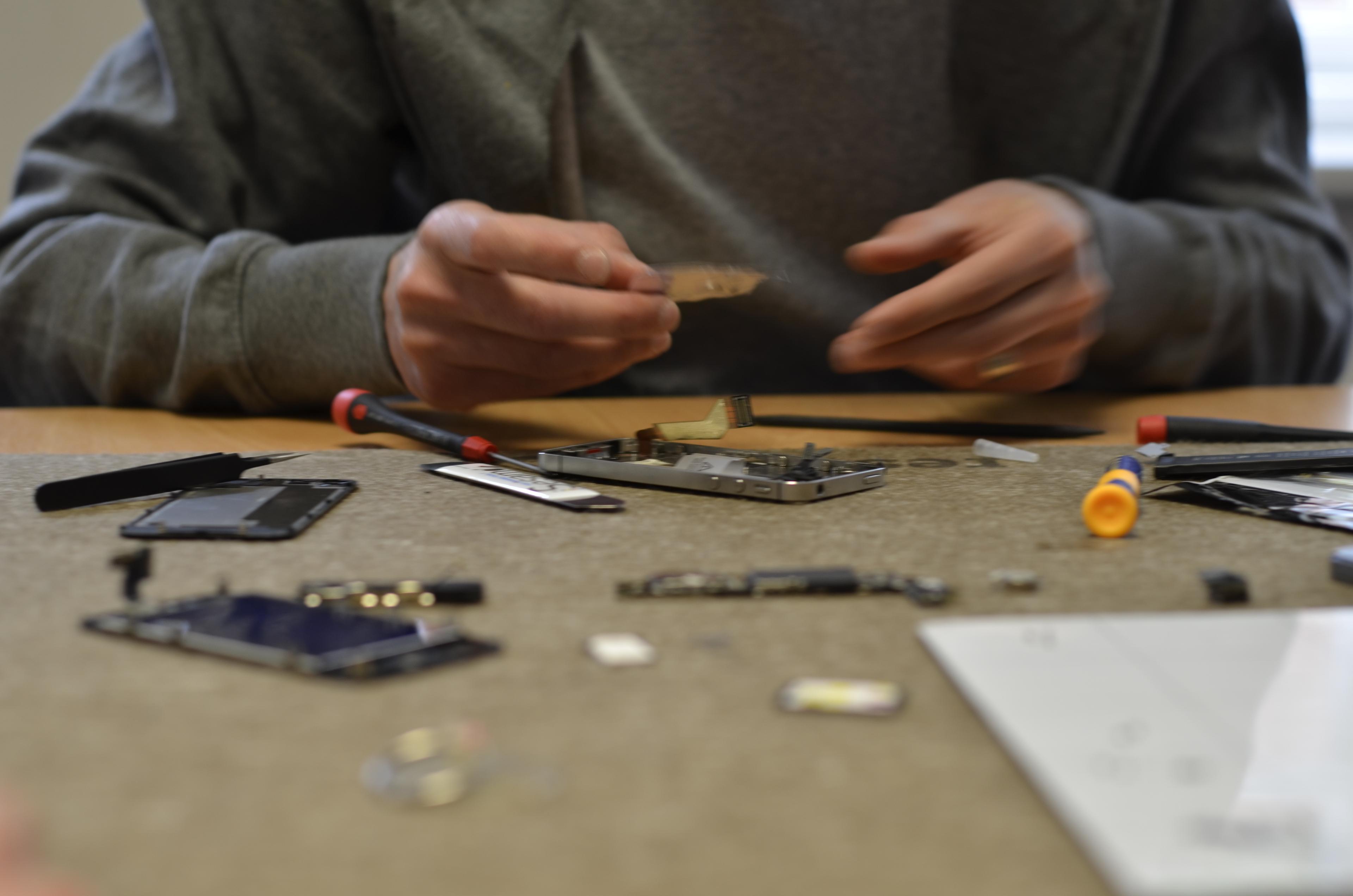 A phone which has been taken apart and is being repaired