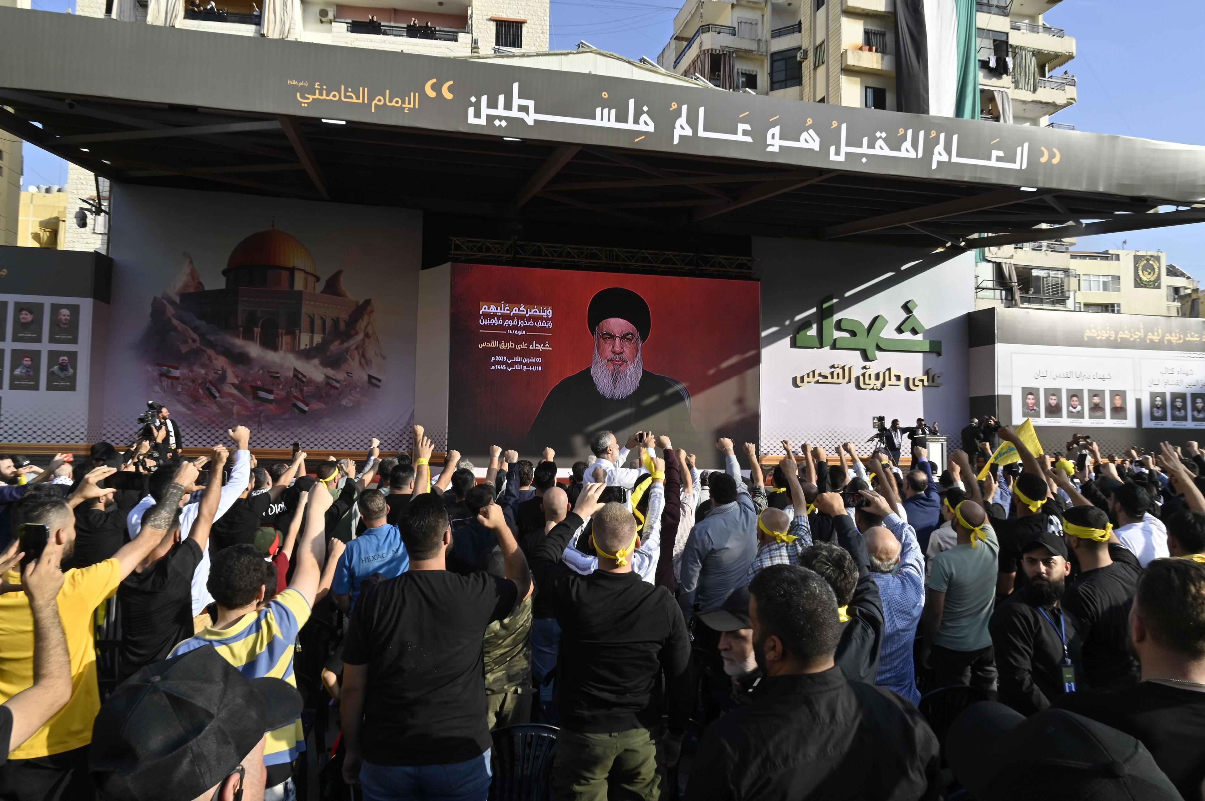 Hassan Nasrallah addresses supporters on a TV screen