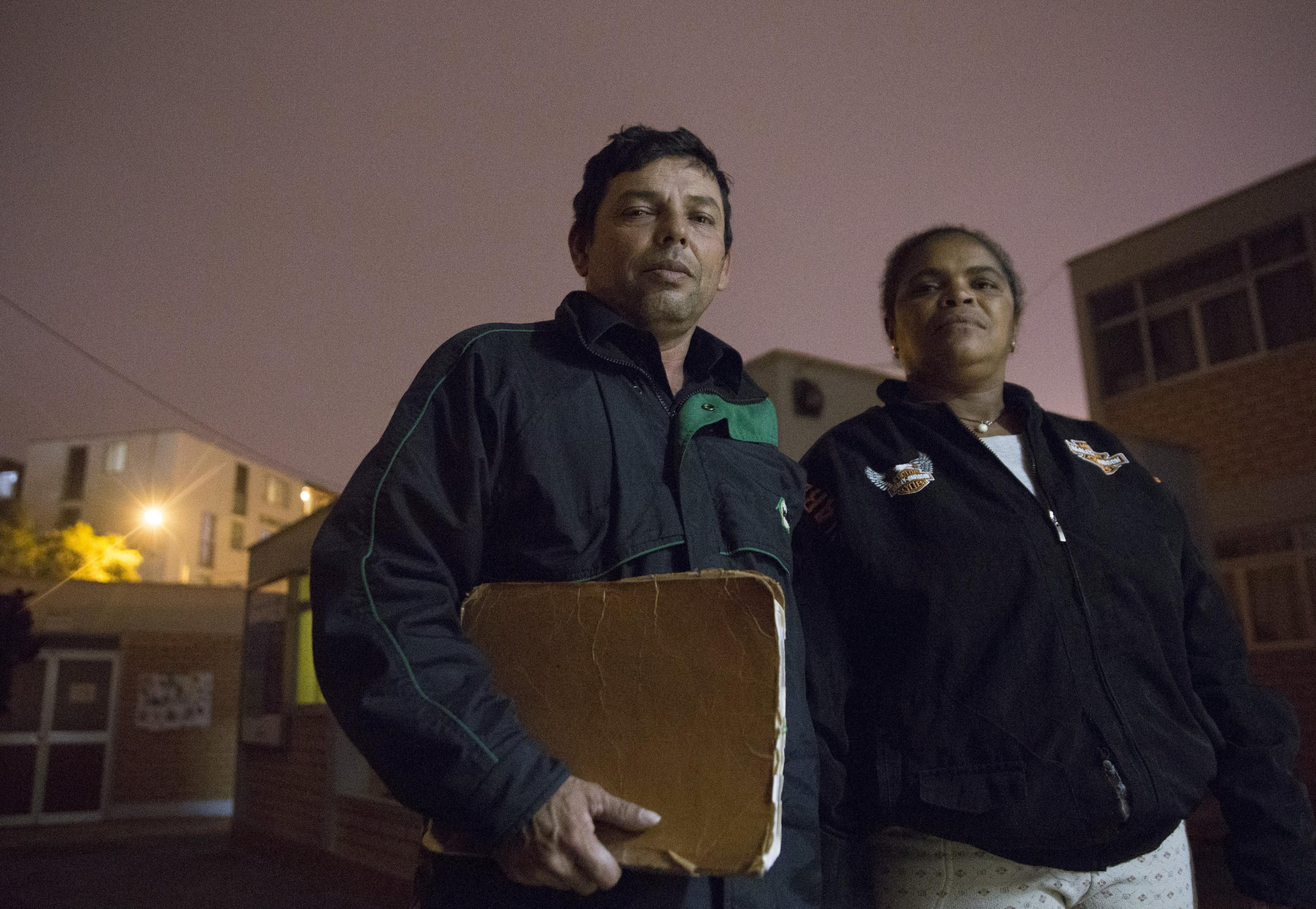 Pedro Carreño and his wife Iris Mendoza pose for a photo near the shelter where they live