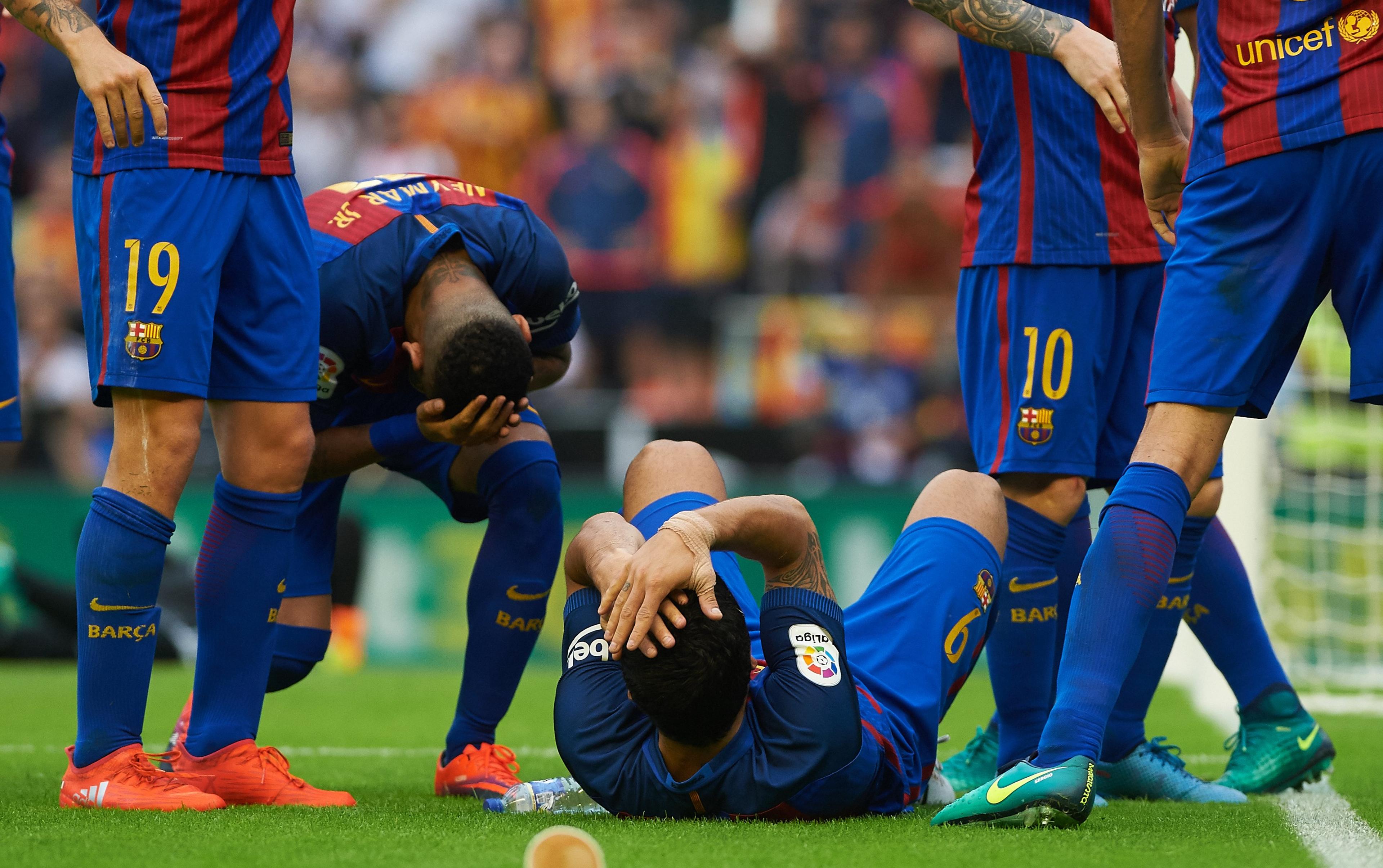 Luis Suarez and Neymar hold their heads after the bottle is thrown