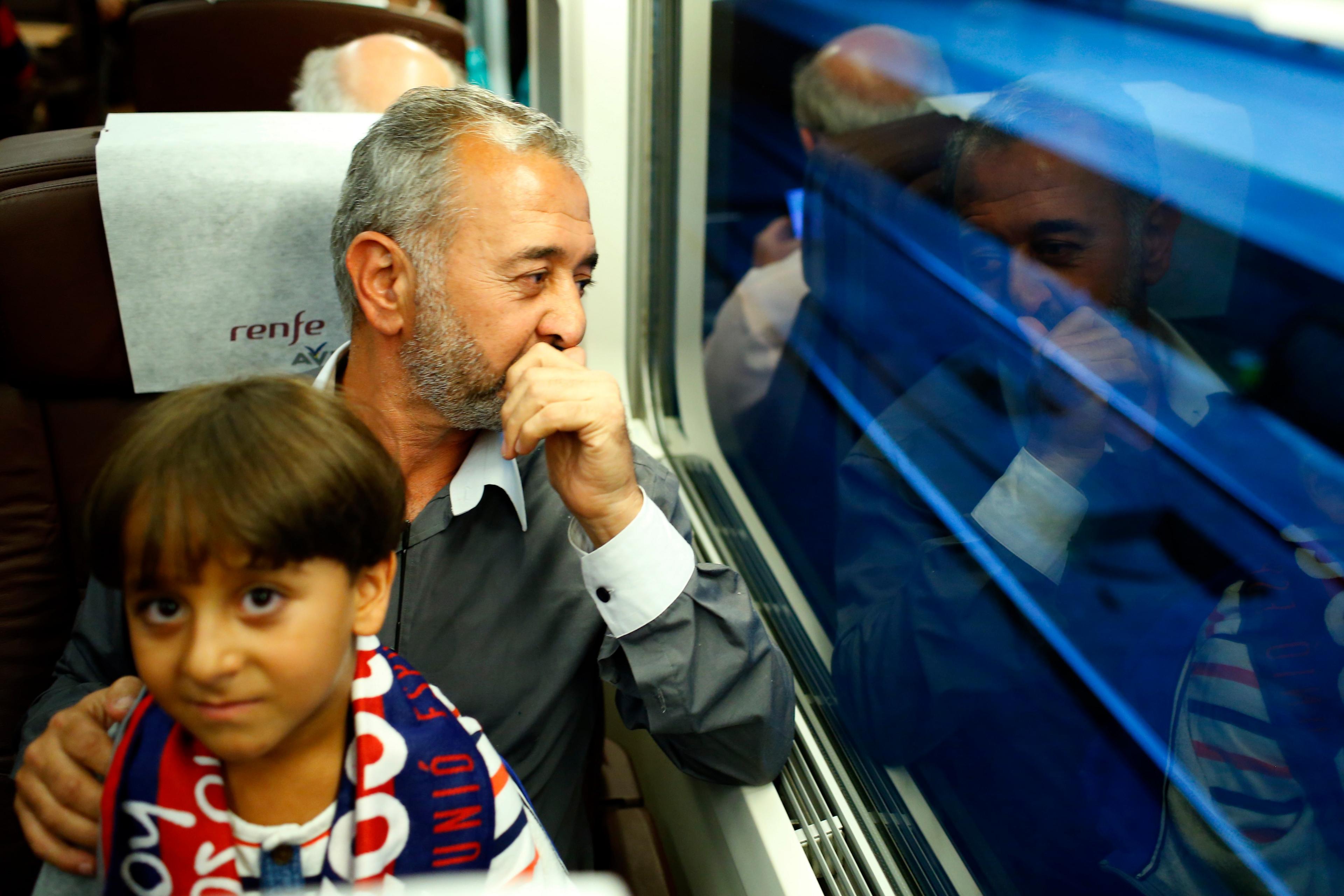 Syrian Osama Abdul Mohsen sits inside the train with his son Zaid as they arrive at the Barcelona train station on Wednesday, Sept.16, 2015.