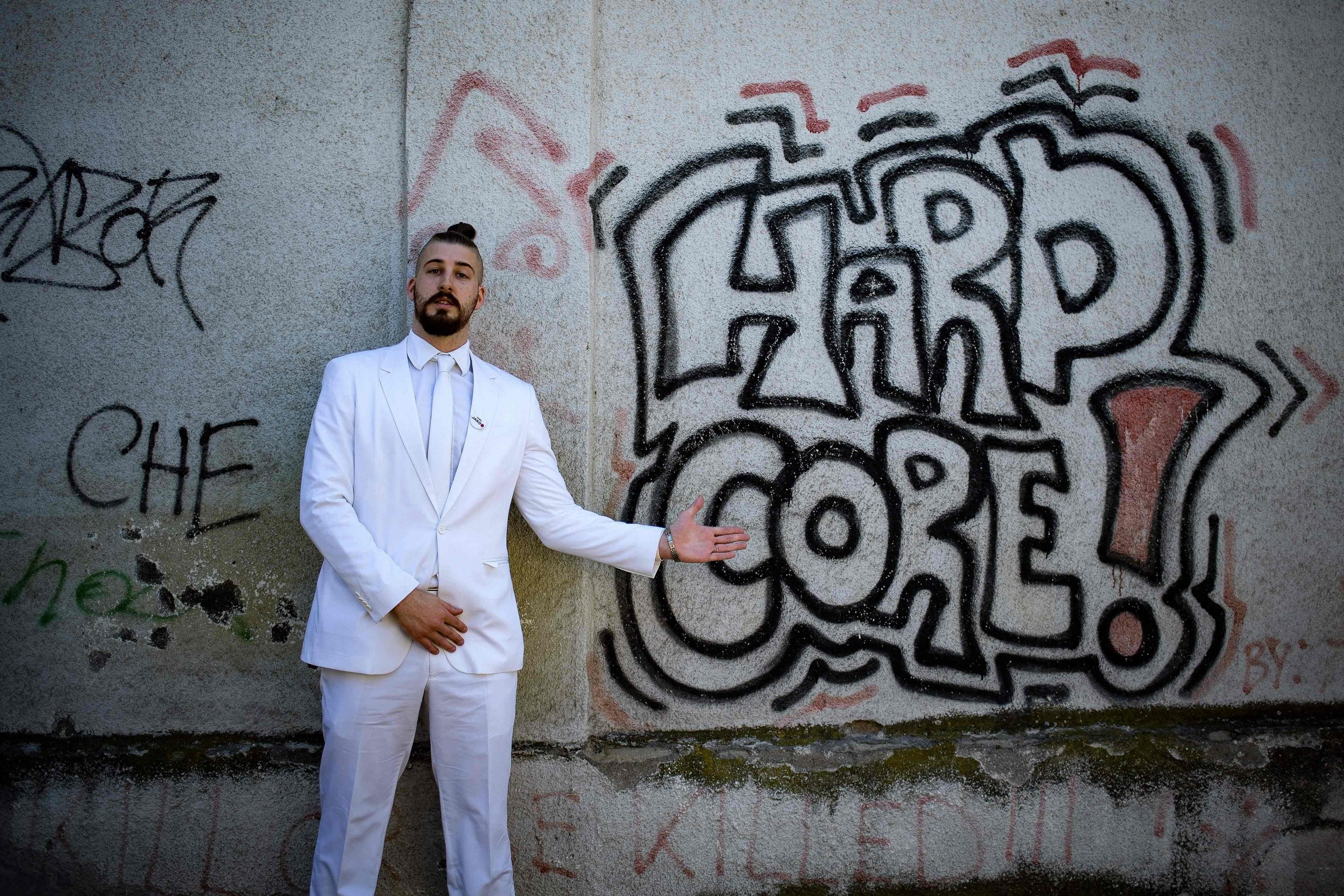 Presidential candidate, Luka Maksimovic alias Beli, a 25-year-old satirist, poses in front of a graffiti in the Serbian town of Mladenovac on March 21, 2017.