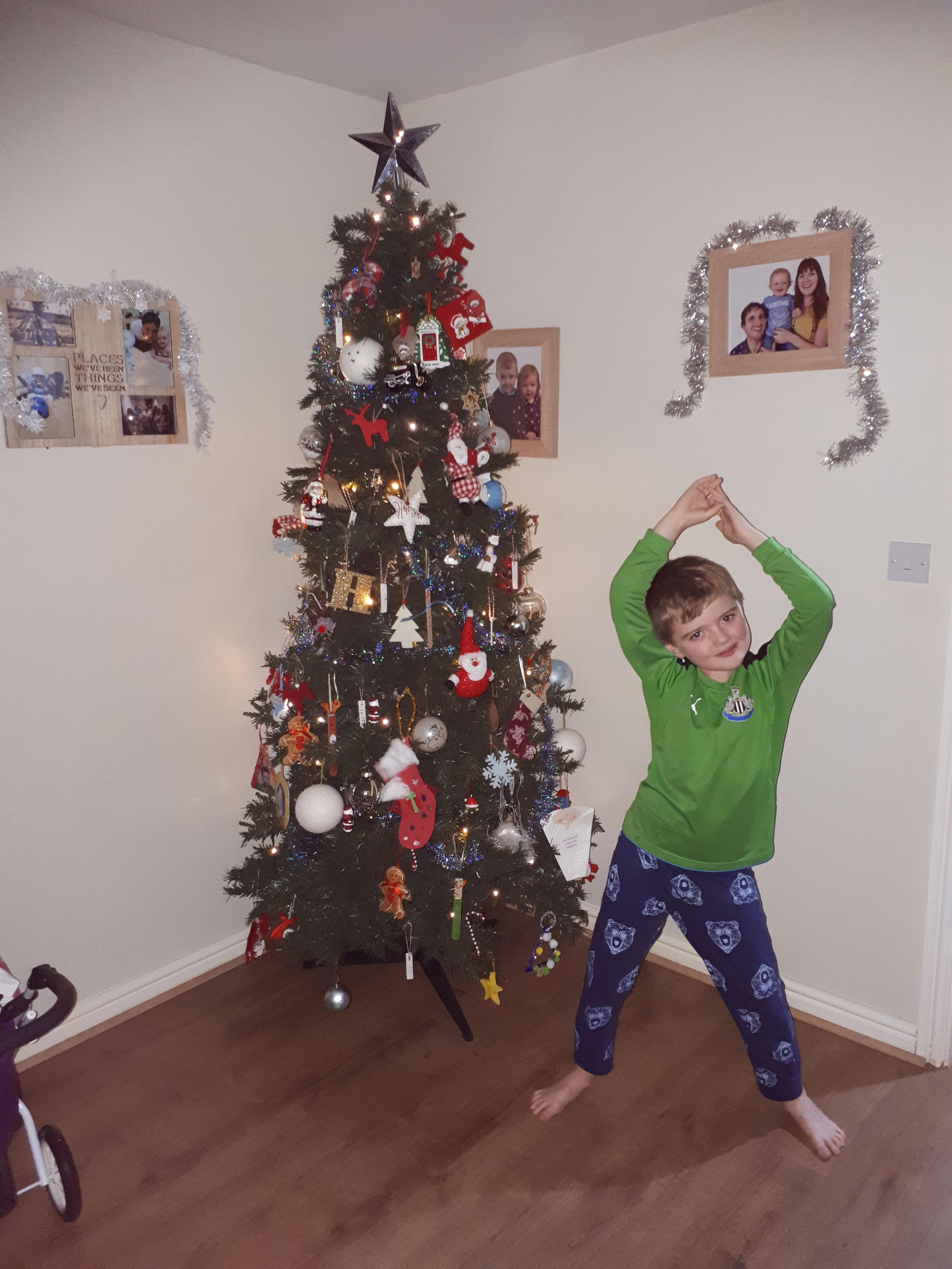 Image of a boy in front of a tree