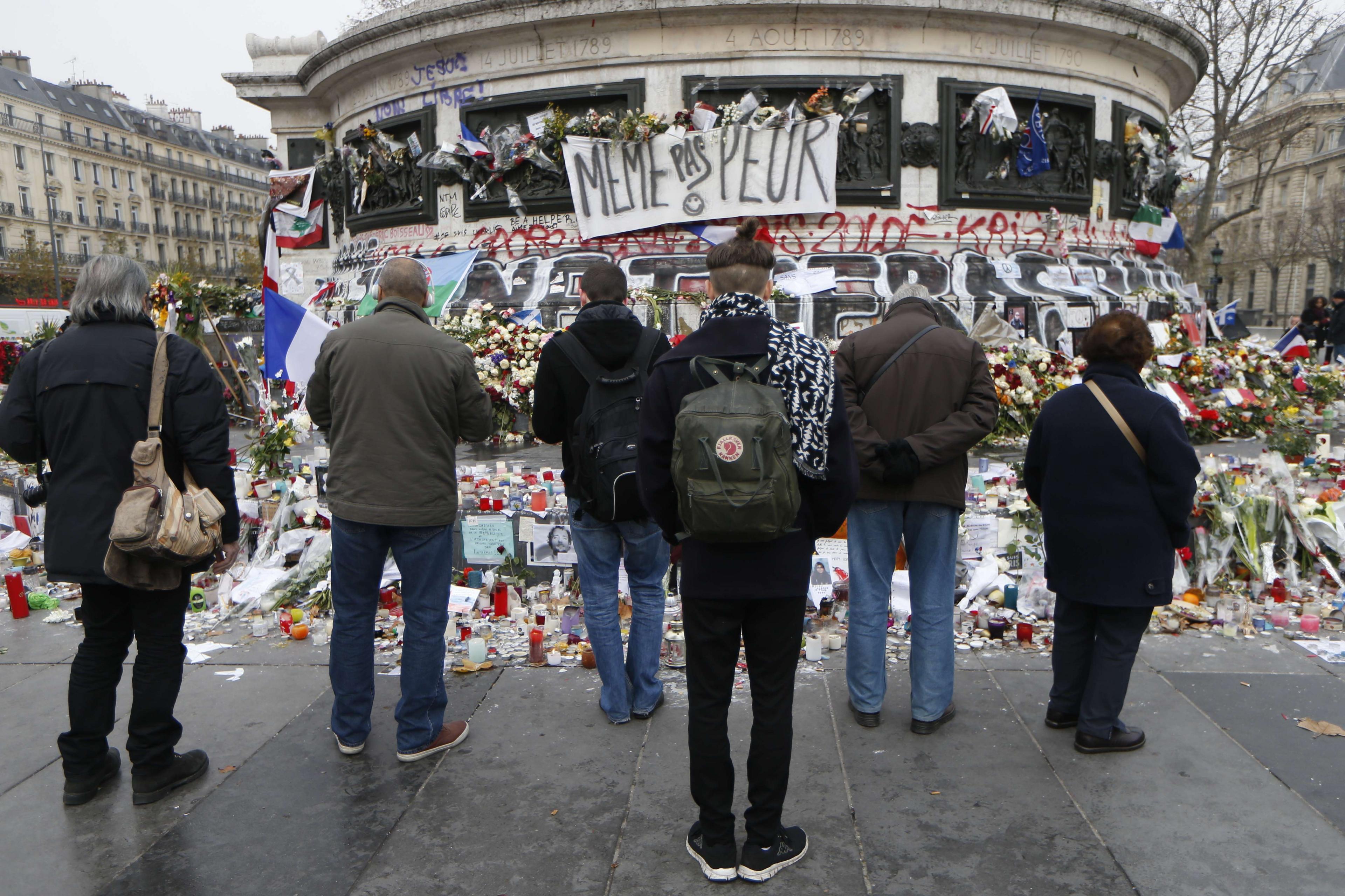 People gathered around a makeshift memorial at Place de la Republique square