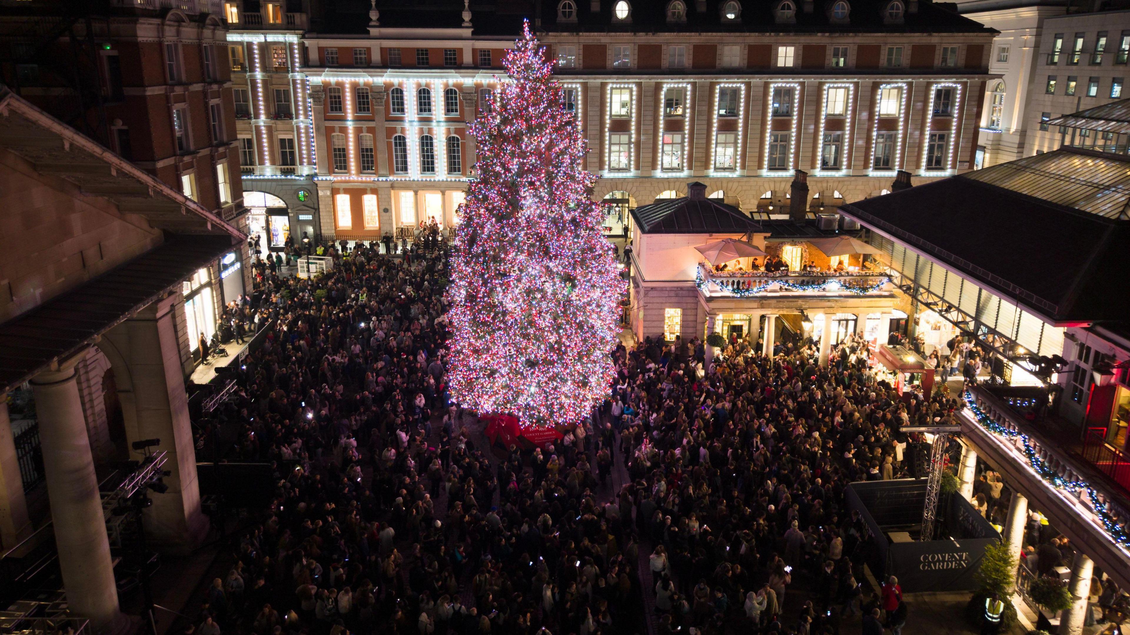 Aerial image of lots of people gathered around a Christmas tree in Covent Garden in London