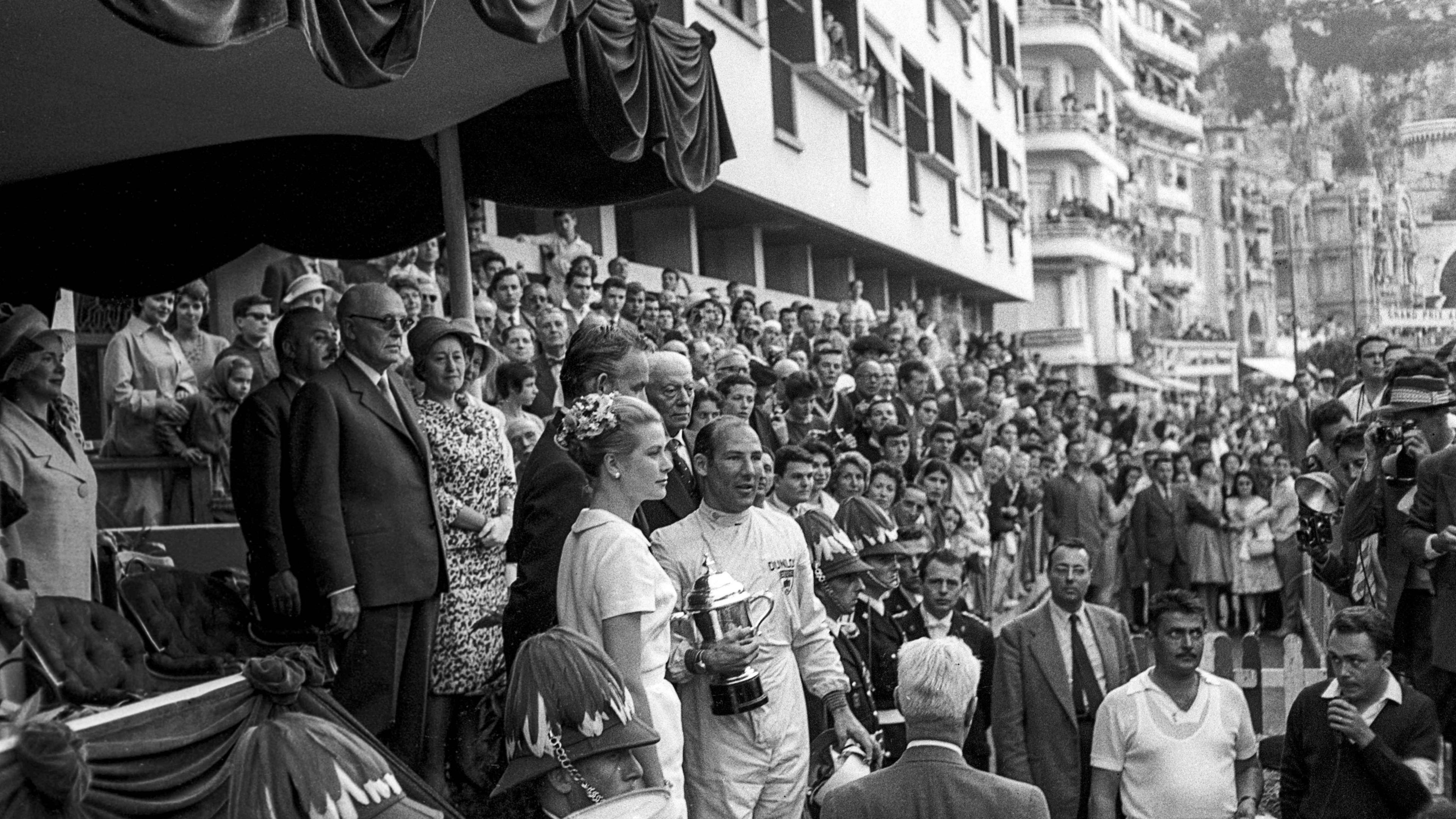 Stirling Moss holds the winner's trophy while standing next to Princess Grace of Monaco in 1960