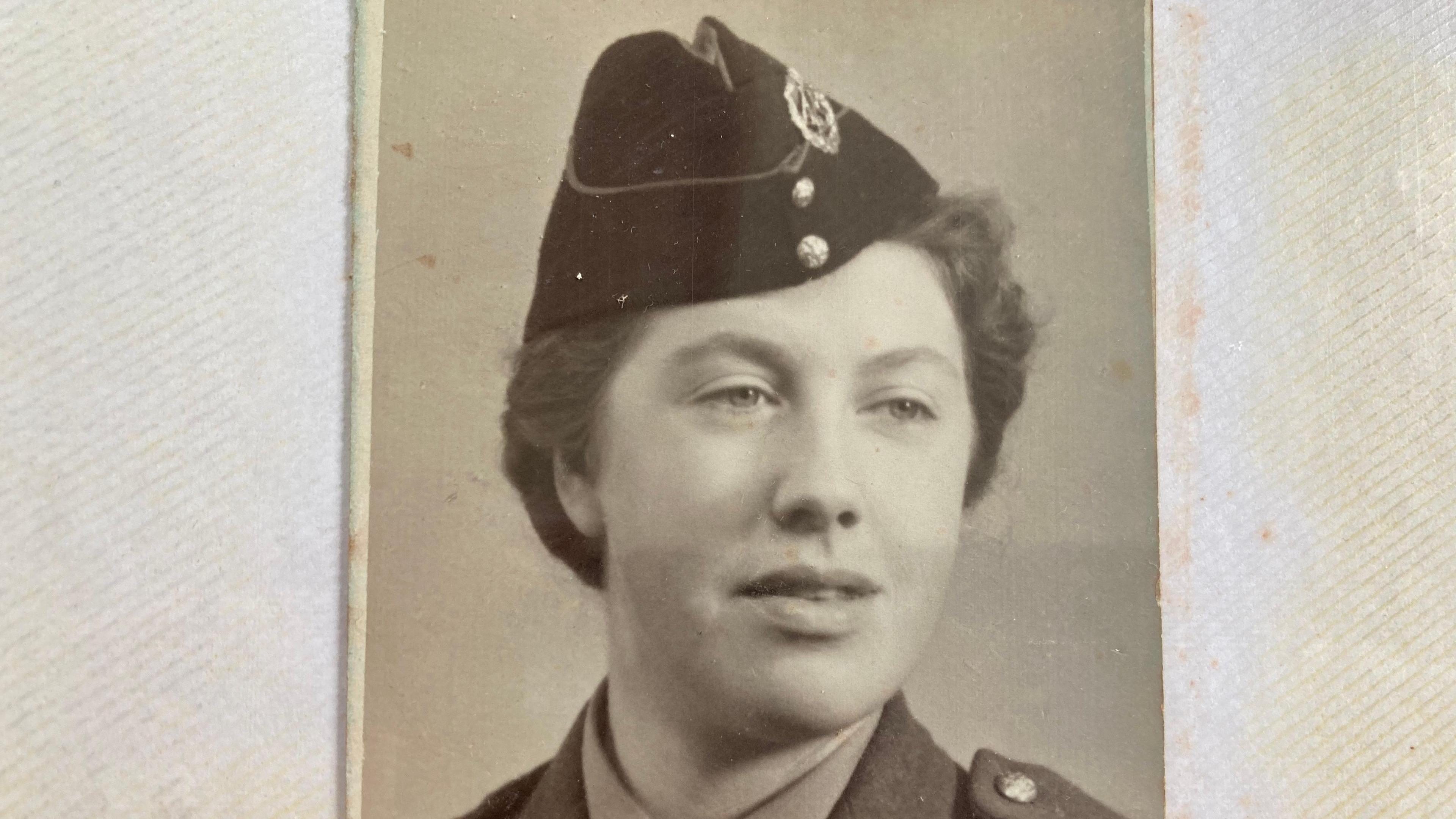 Doreen Lemon, in World War II uniform, with a hat and hair tied back. The image is in black and white.  