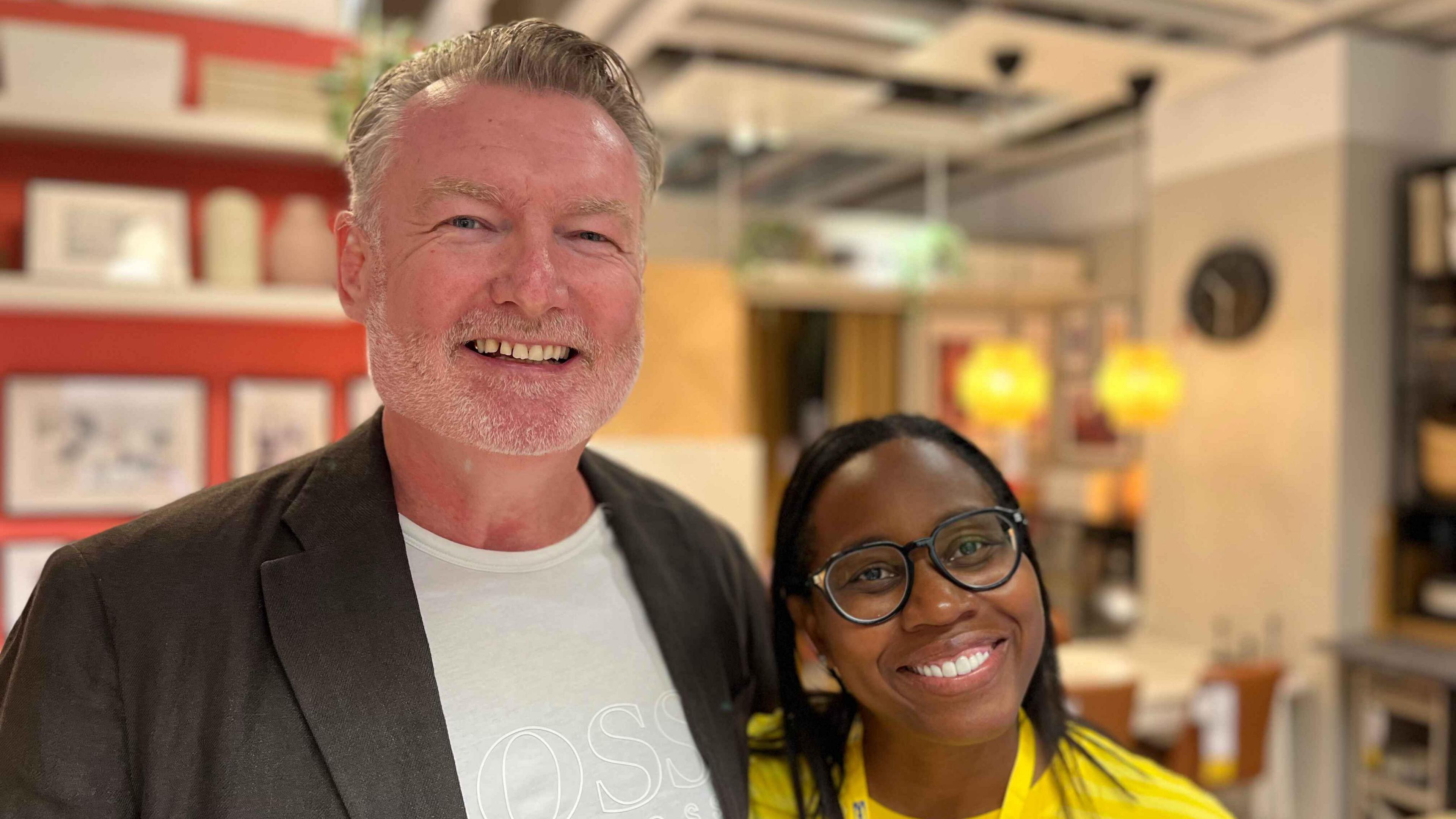 Mark Buchanan-Smith, centre manager for Churchill Square, and Karina Gilpin, store manager. Mark is wearing a suit jacket and Karina a yellow Ikea t-shirt. Both are smiling at the camera and are standing in one of the store's show houses
