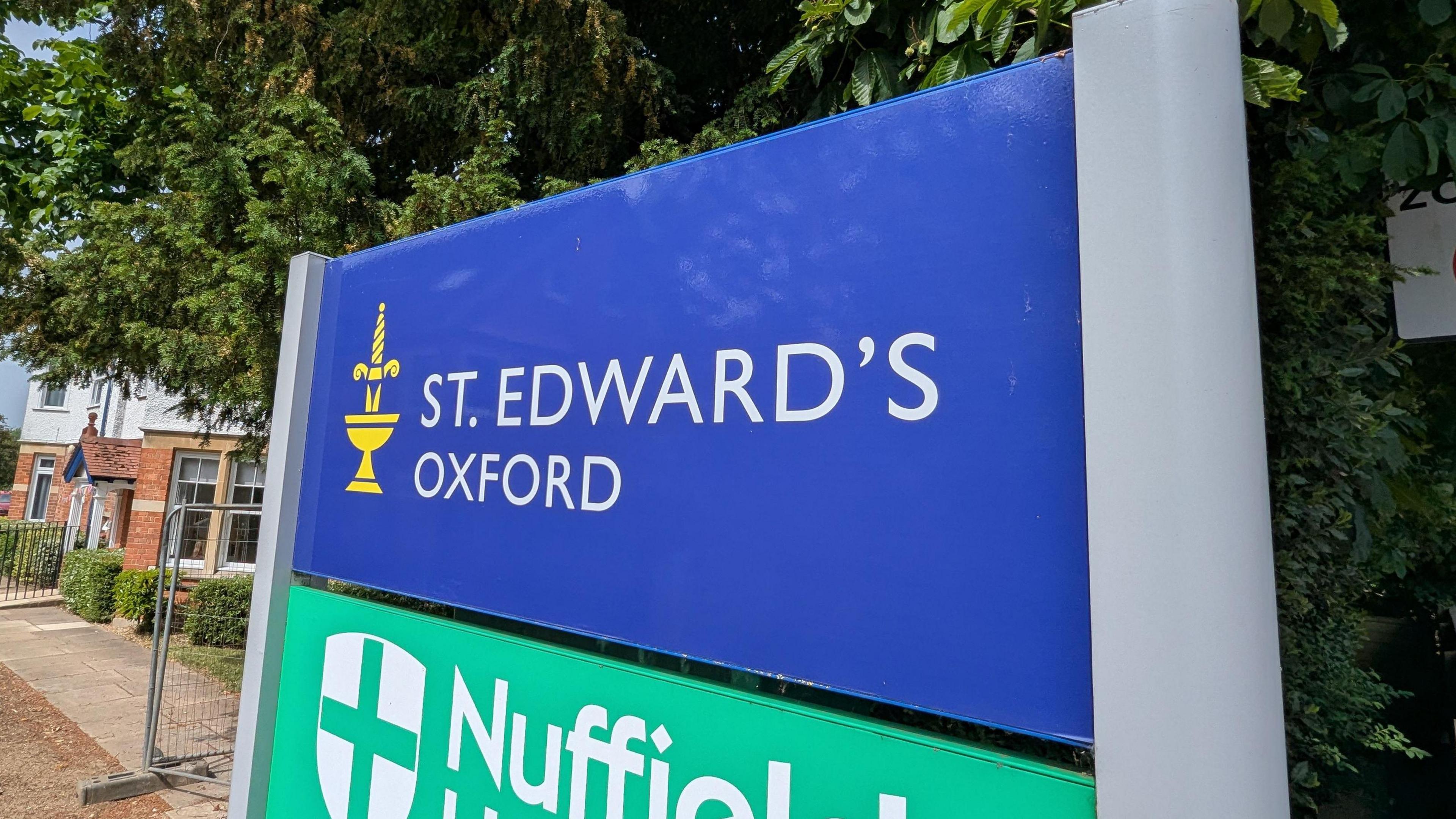 A blue sign with white writing that says 'St Edward's Oxford'.