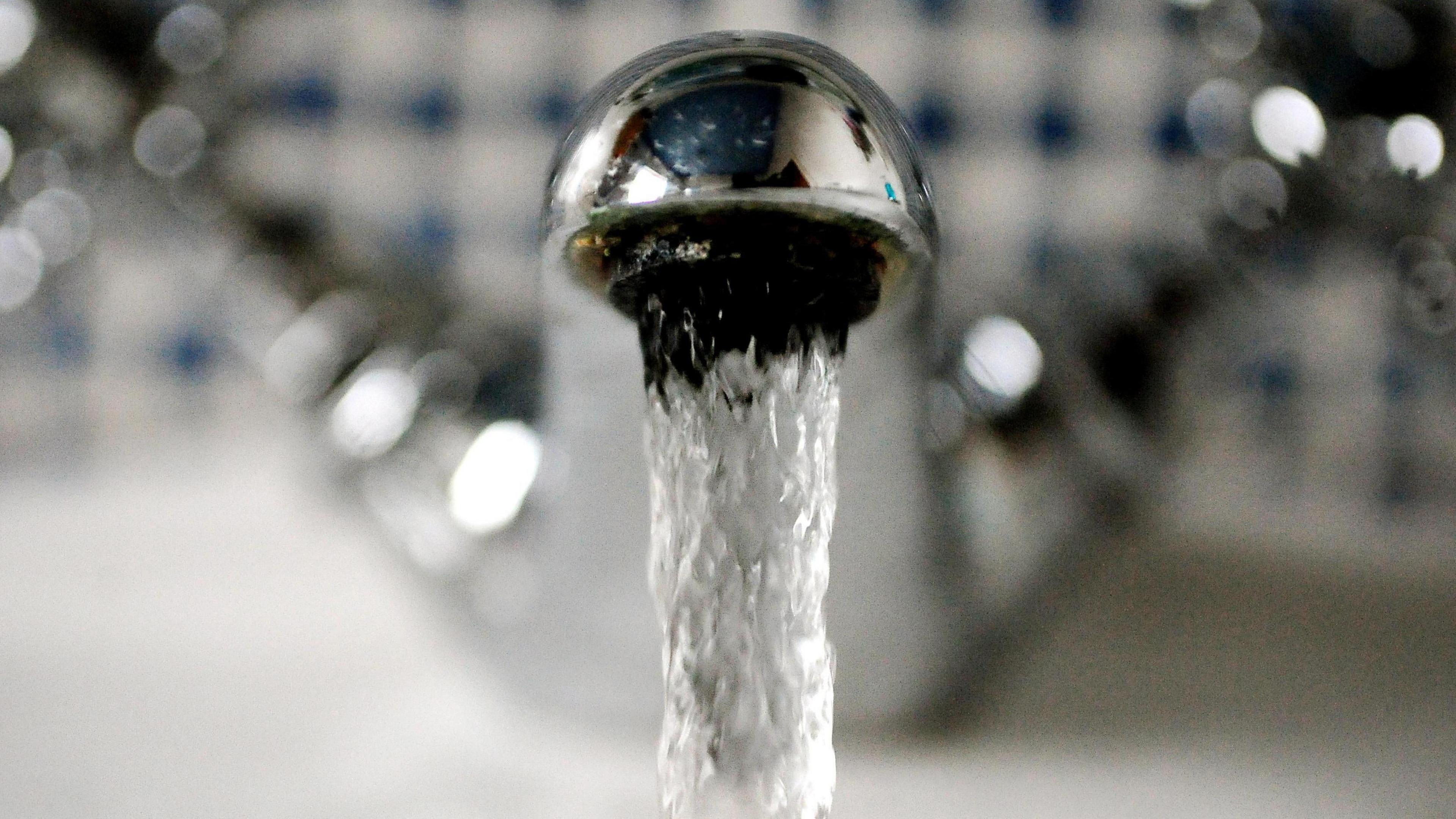 Water runs out of a silver tap