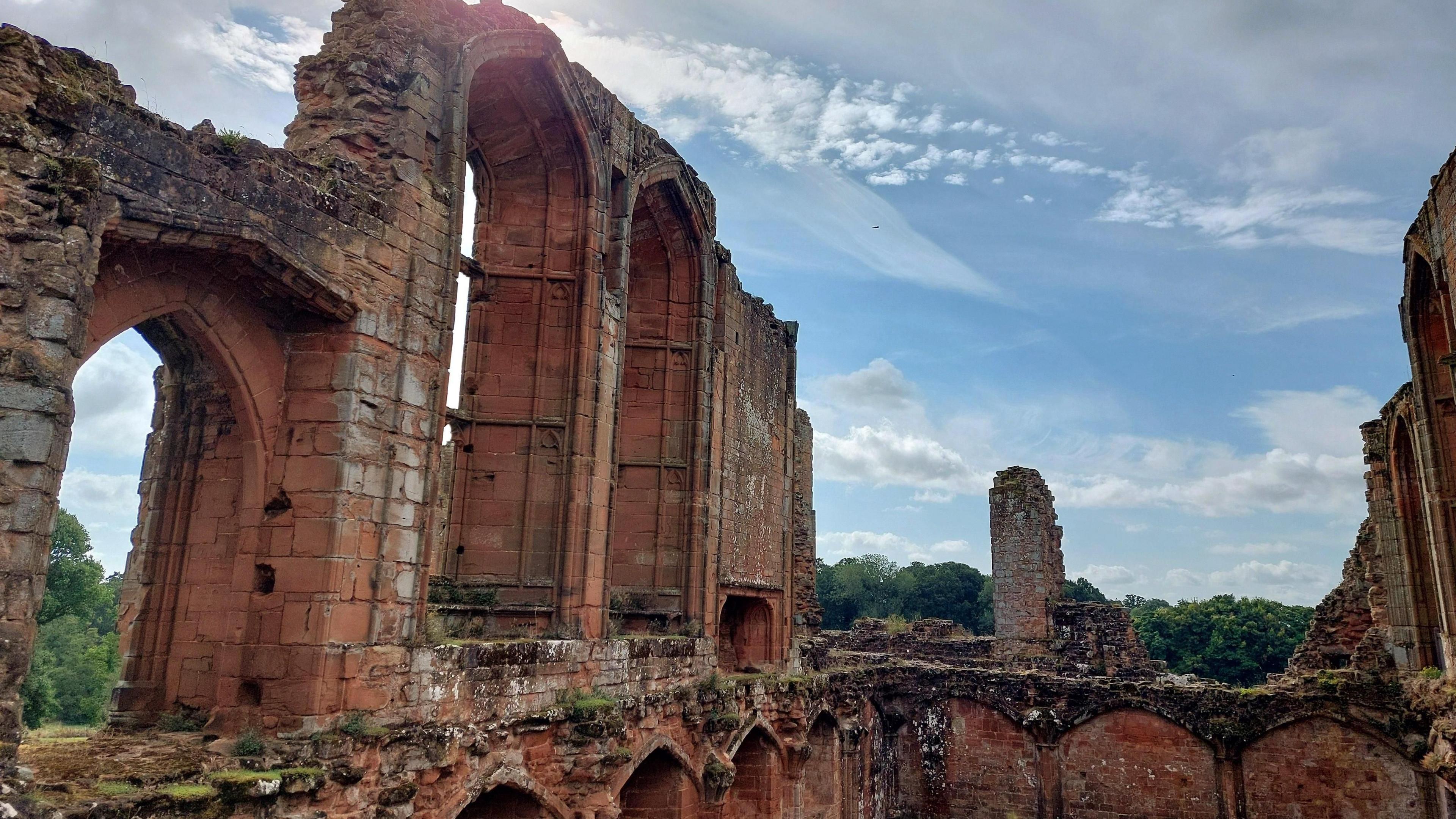 Kenilworth castle ruins, against a blue sky with light white clouds 