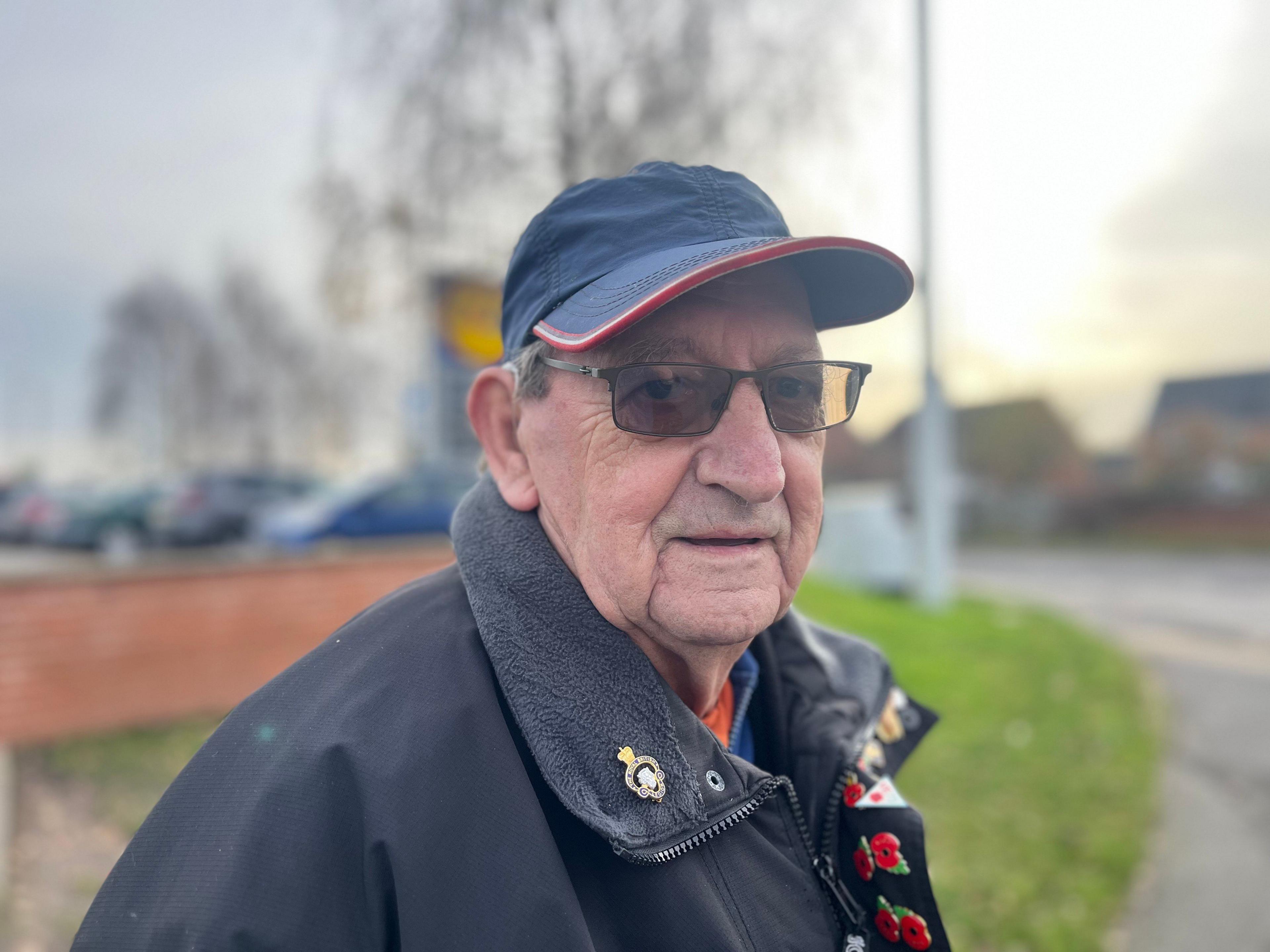 A shopper pictured outside Lidl. He is wearing a hat and coat.