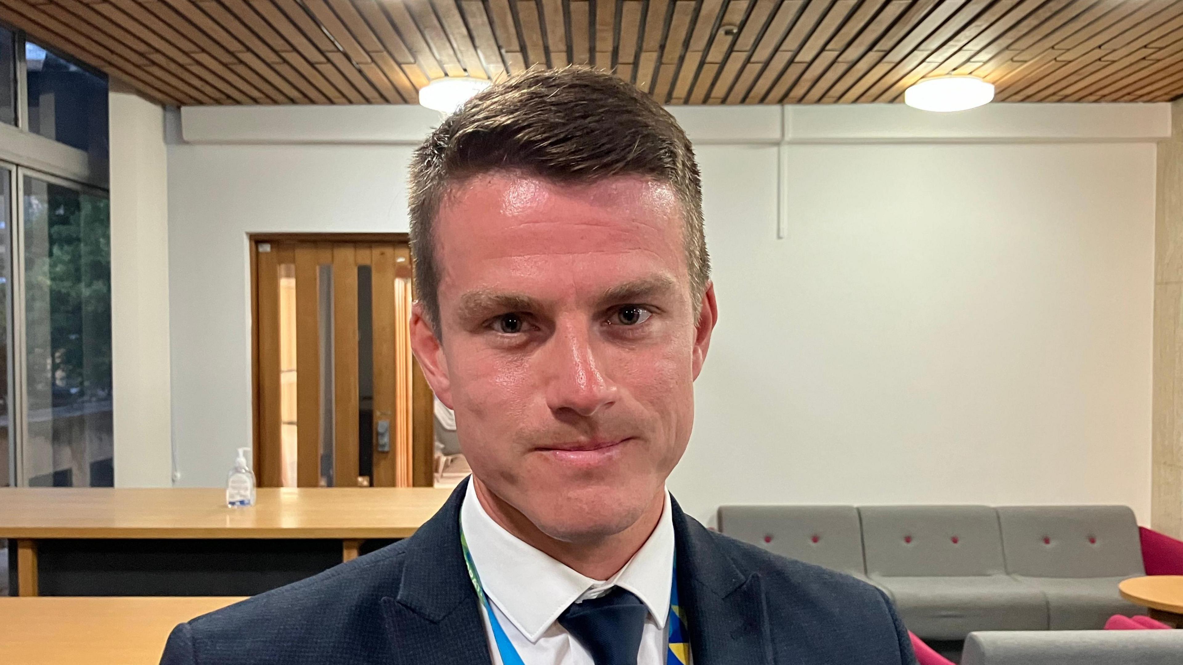 A head and shoulders shot of Cllr Jack Warren dressed in a suit and tie 