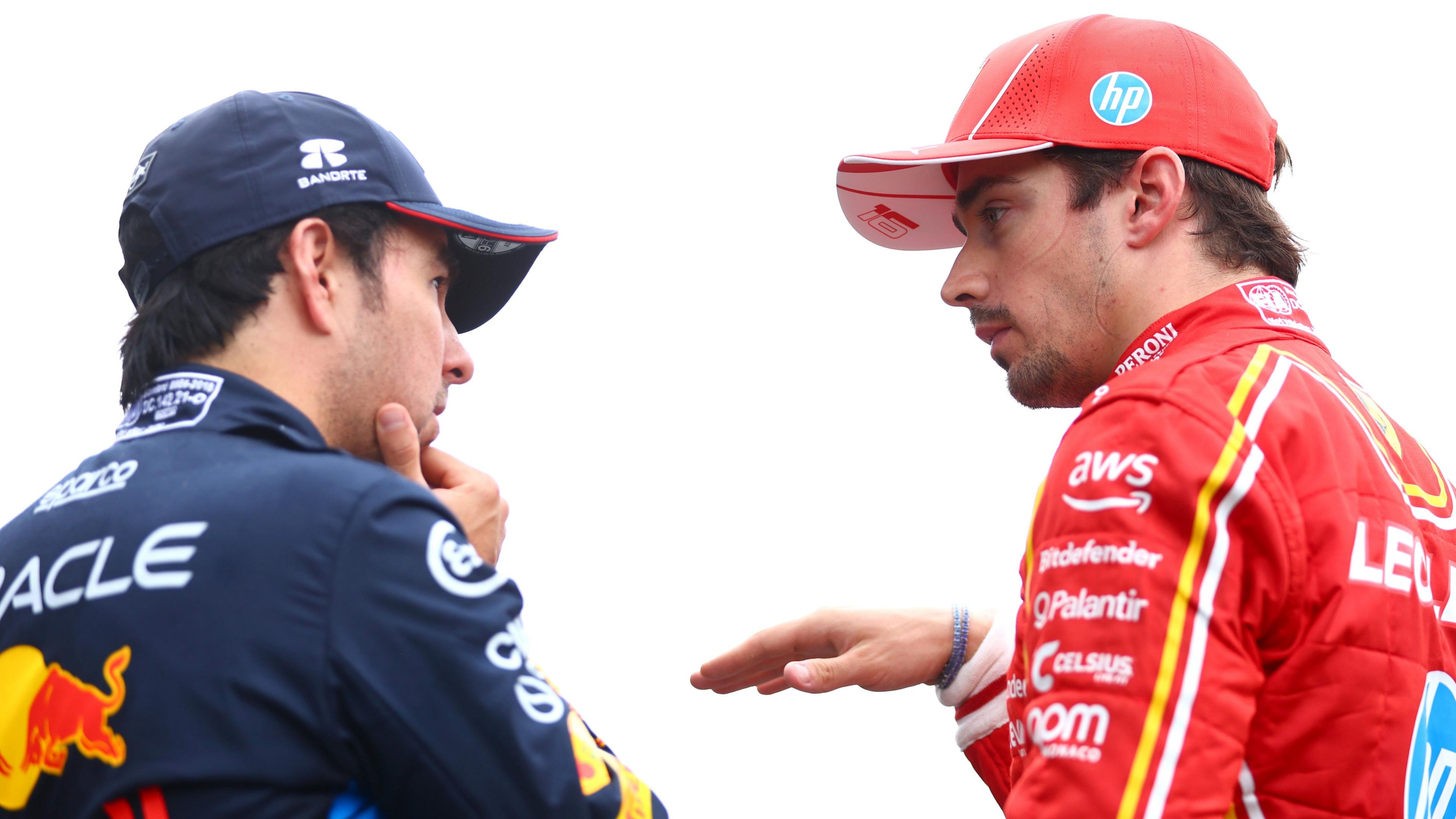 Charles Leclerc gesticulates while in discussion with Sergio Perez