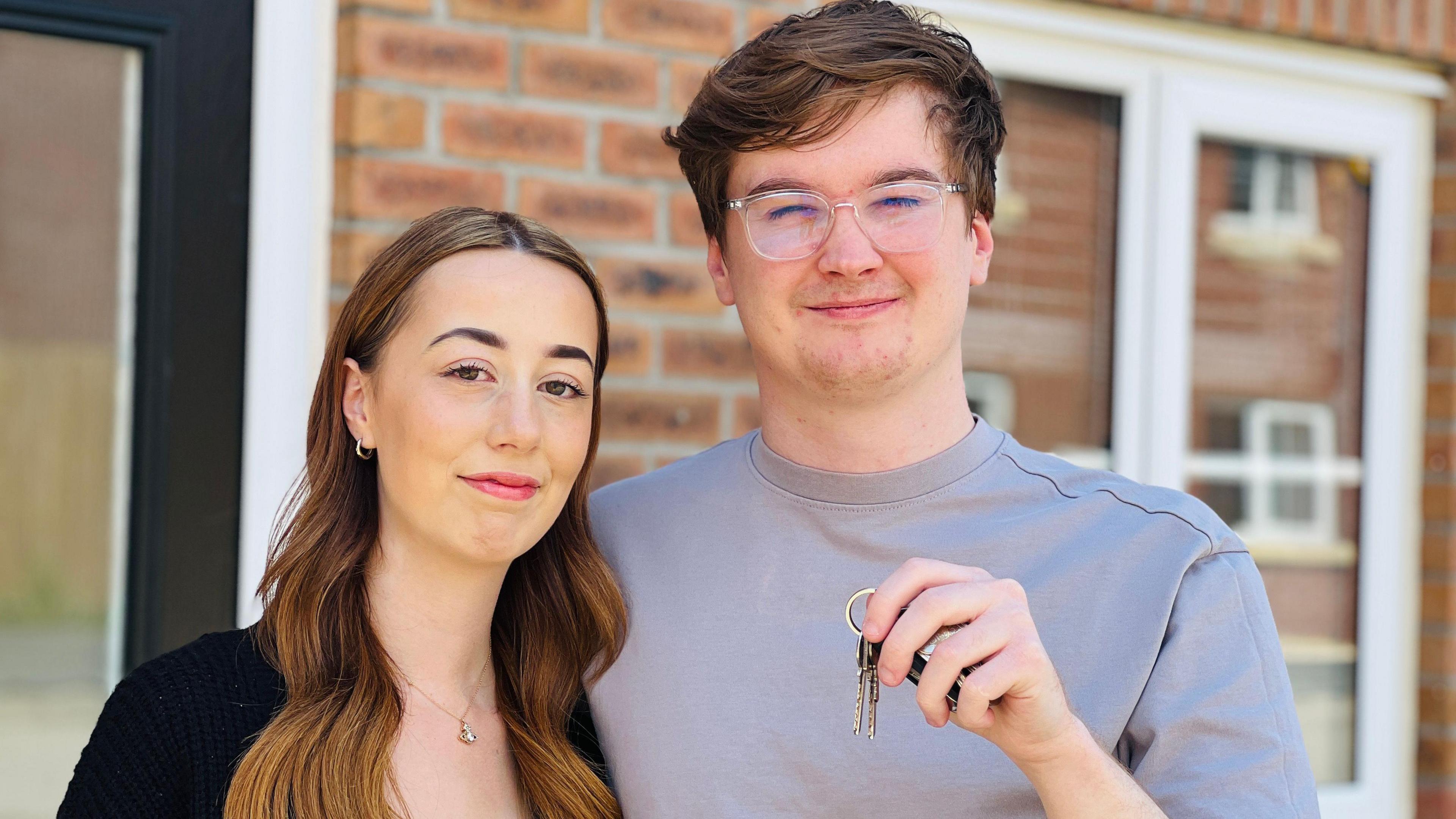 George Musgrave and Courtney Walls standing outside their first home