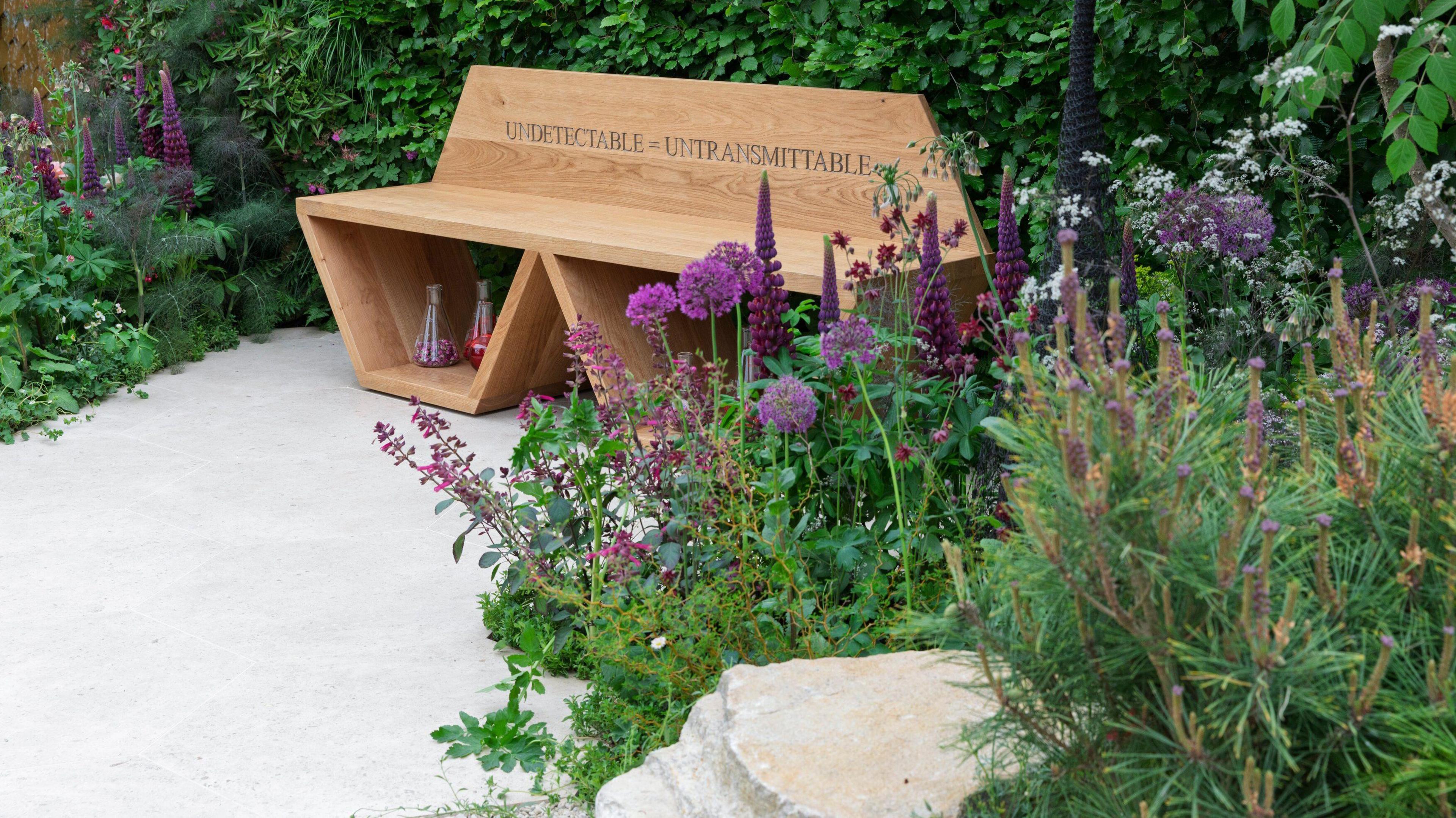 A bench sits in the garden with the words 'Undetectable = Untransmittable' written on it as a sign of
