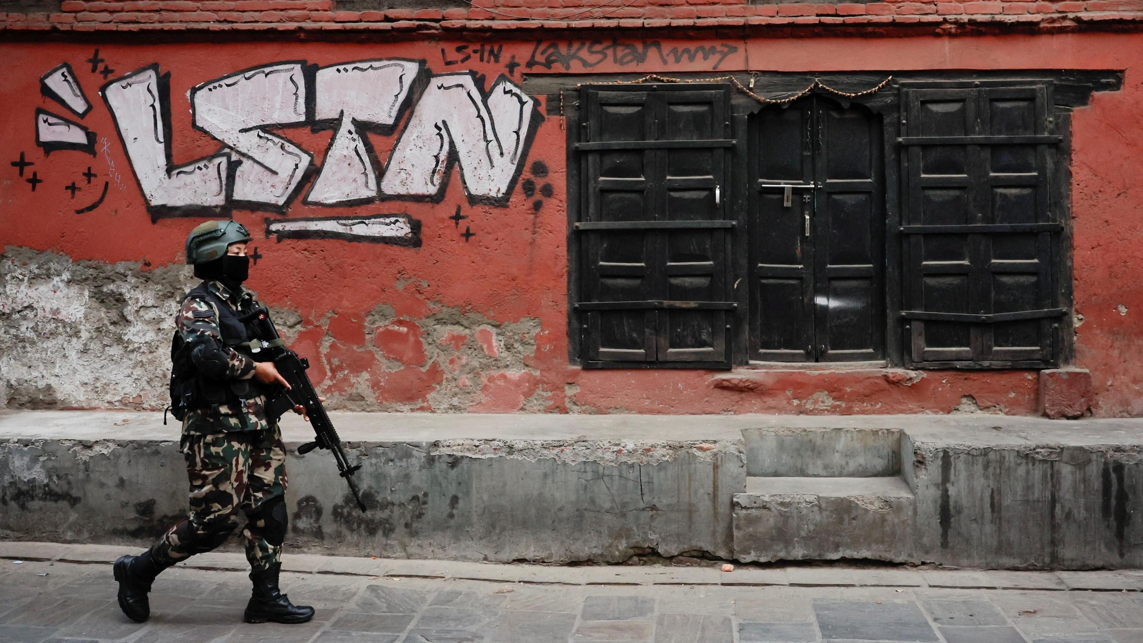 Një anëtar i ushtrisë nepaleze patrullon një rrugë përpara zgjedhjeve të Dhomës së Përfaqësuesve të planifikuara për 5 mars 2026, pas protestave vdekjeprurëse anti-korrupsion të udhëhequra nga "Gjenerata Z" në shtator që rrëzuan qeverinë, në Lalitpur të Nepalit. Një mur i kuq mund të shihet pas tij me grafite që thonë "lstn".