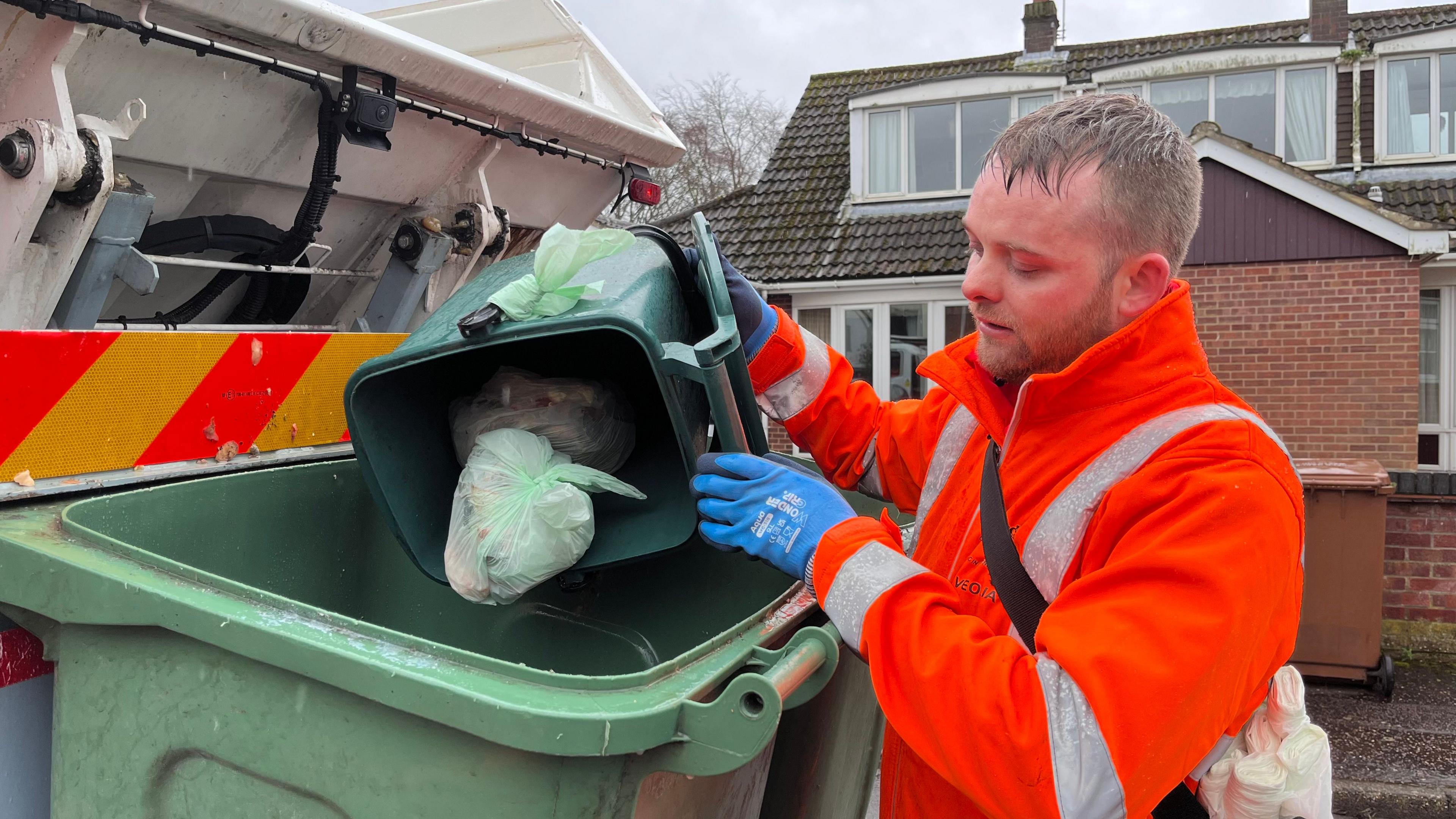 Bin man collecting food waste 