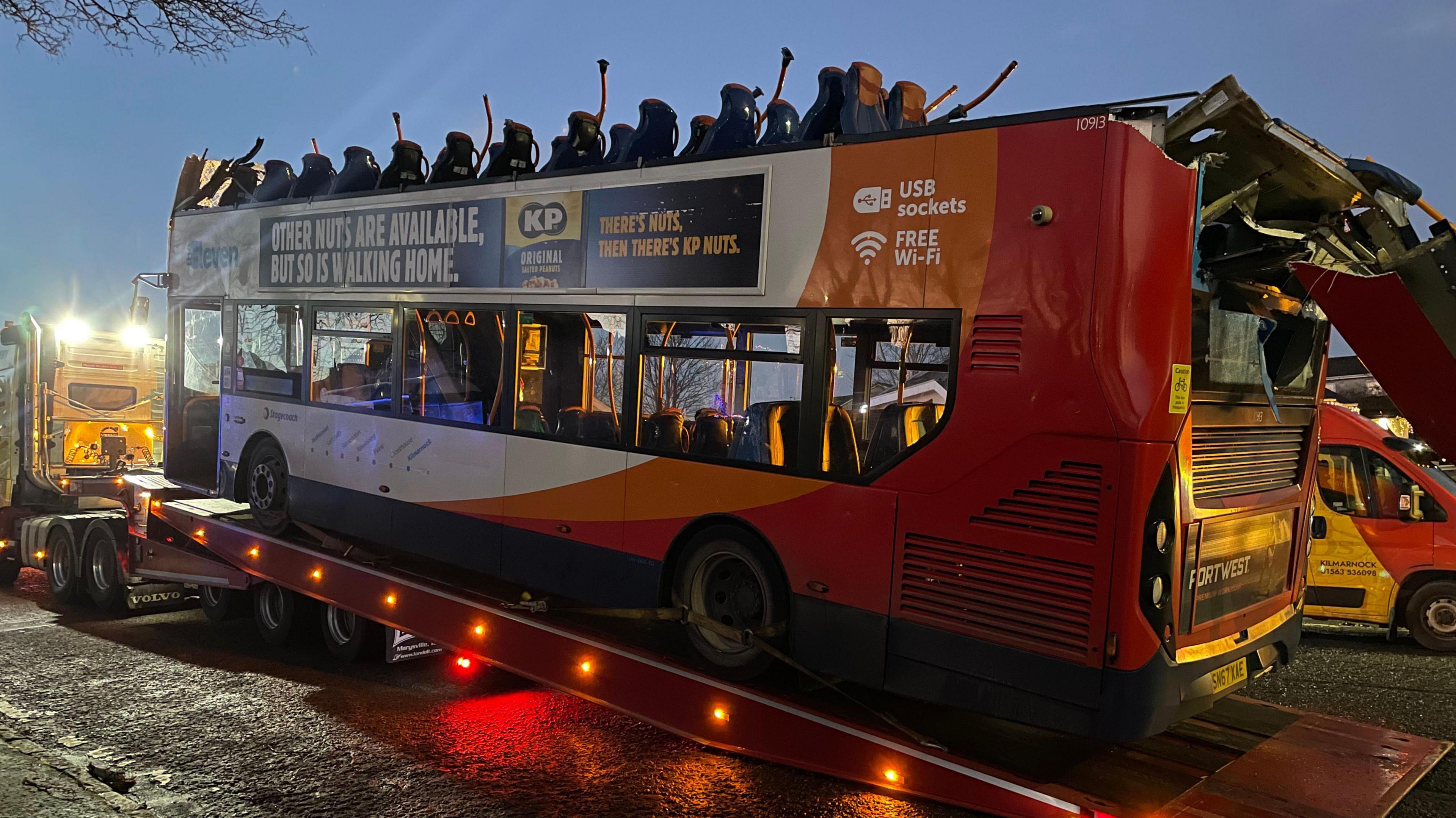 A roofless double decker Stageboach bus being loaded onto the back of a lorry