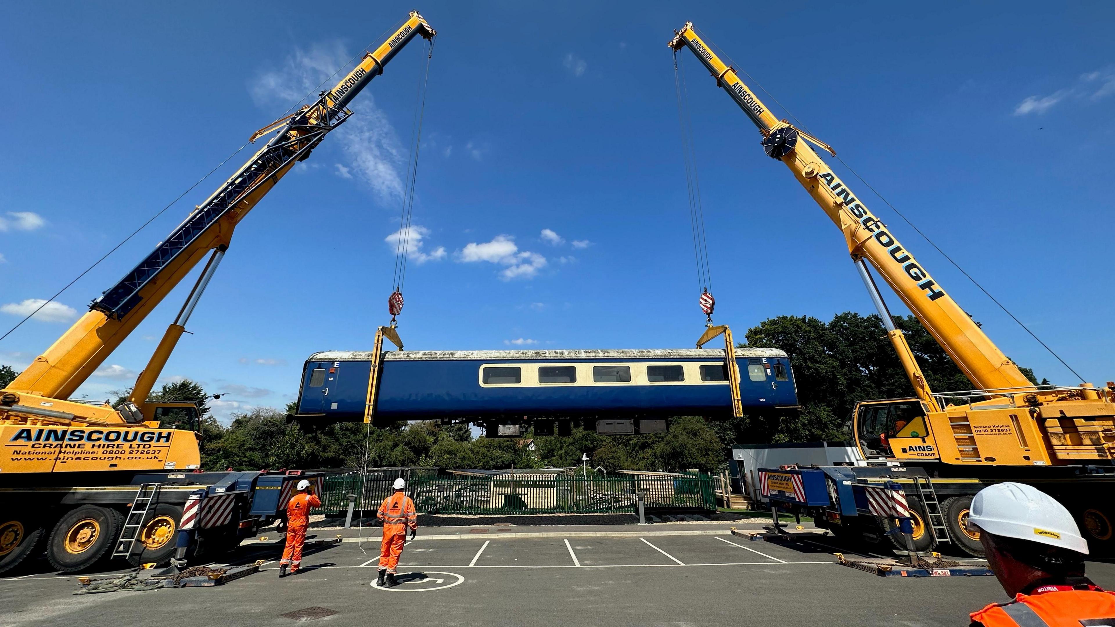 Carriage being lowered into place using cranes