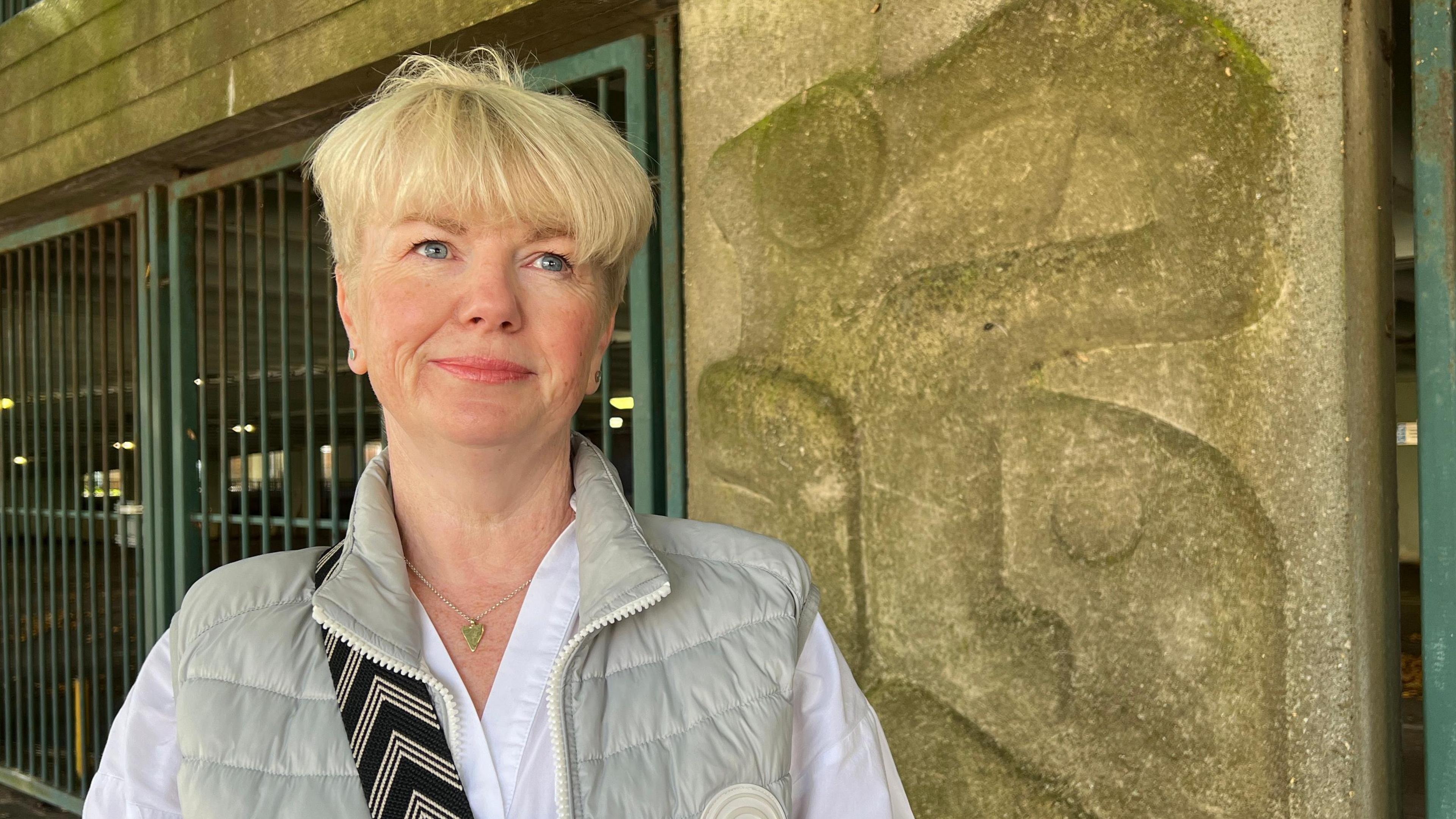 Kerry Henderson standing next to the car park with one of the artworks visible