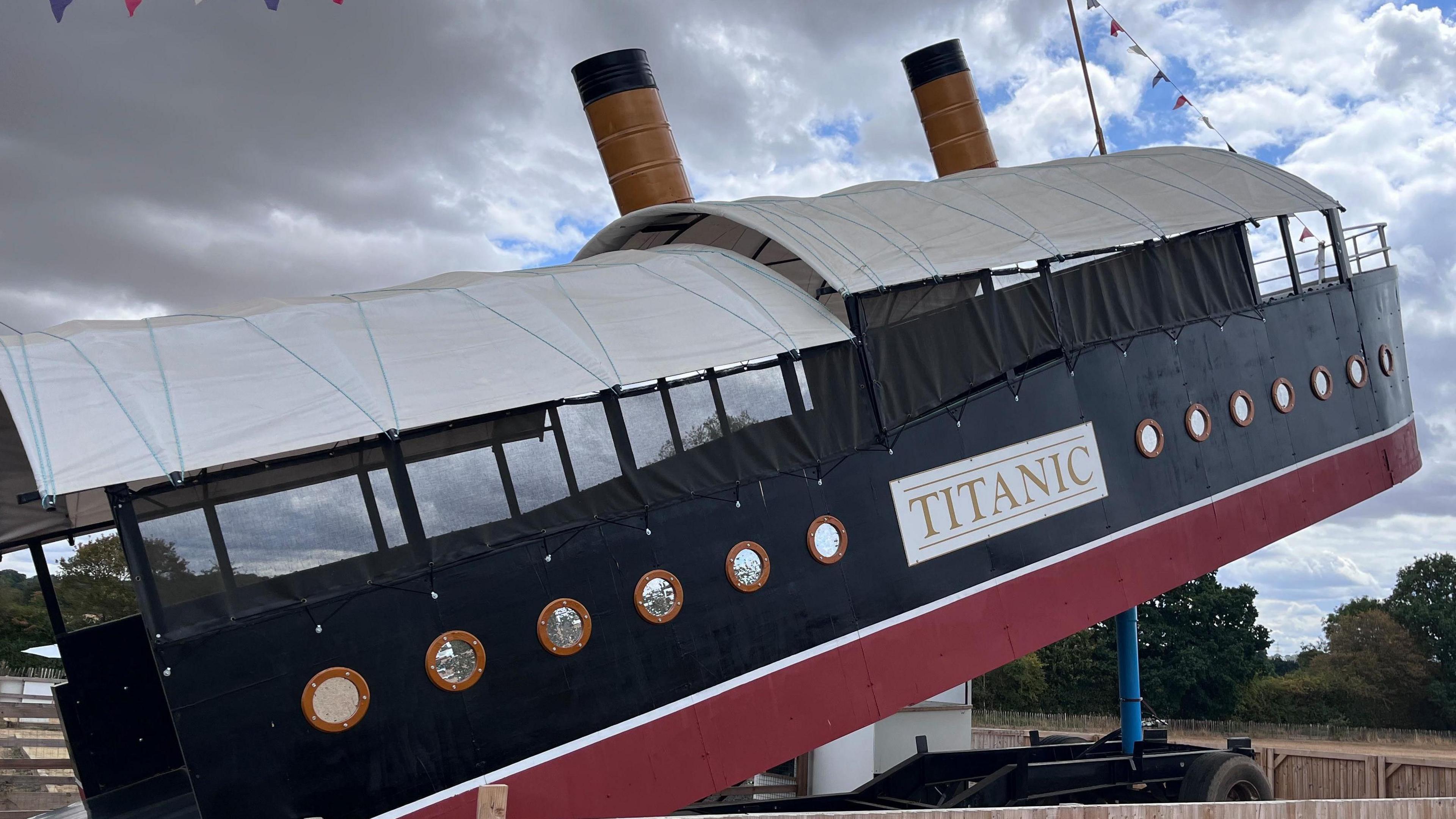 An outdoor hydraulic slide designed to look like Titanic. It has a red and blue exterior with a large sign that reads "Titanic". 