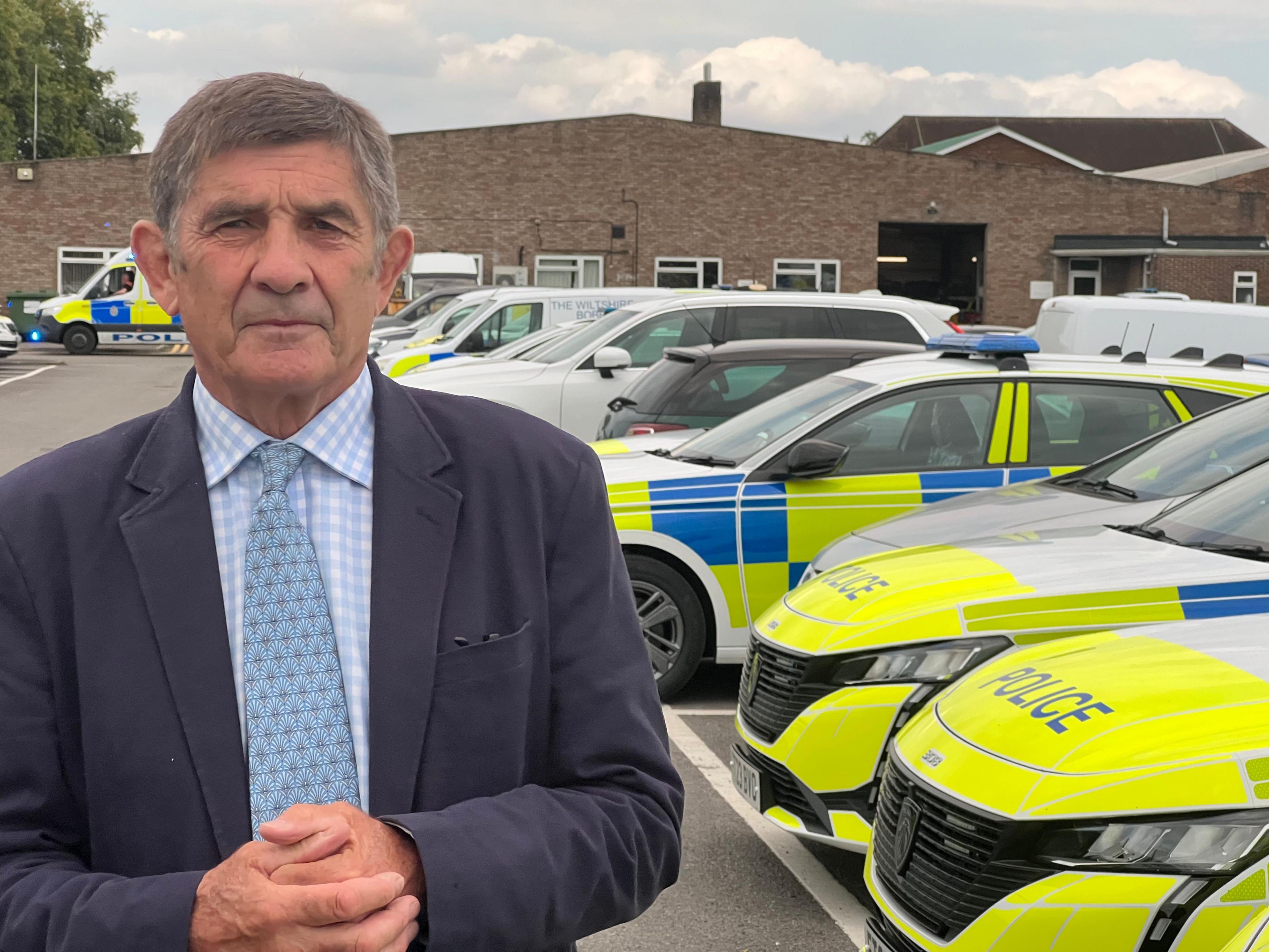 PCC Philip Wilkinson in front of a fleet of police cars in Devizes