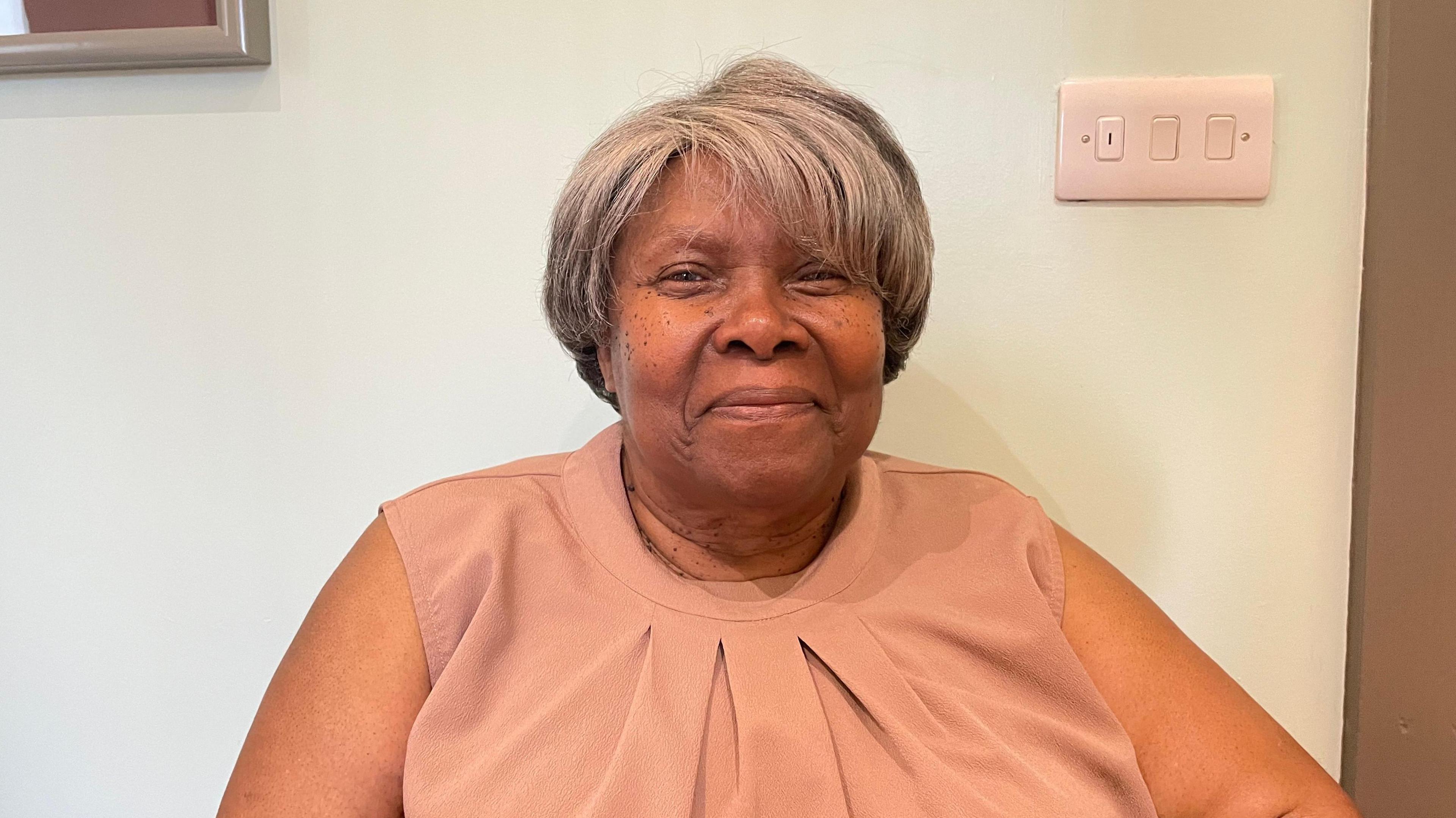 Blanche Mcpherson sits in front of a white-coloured wall