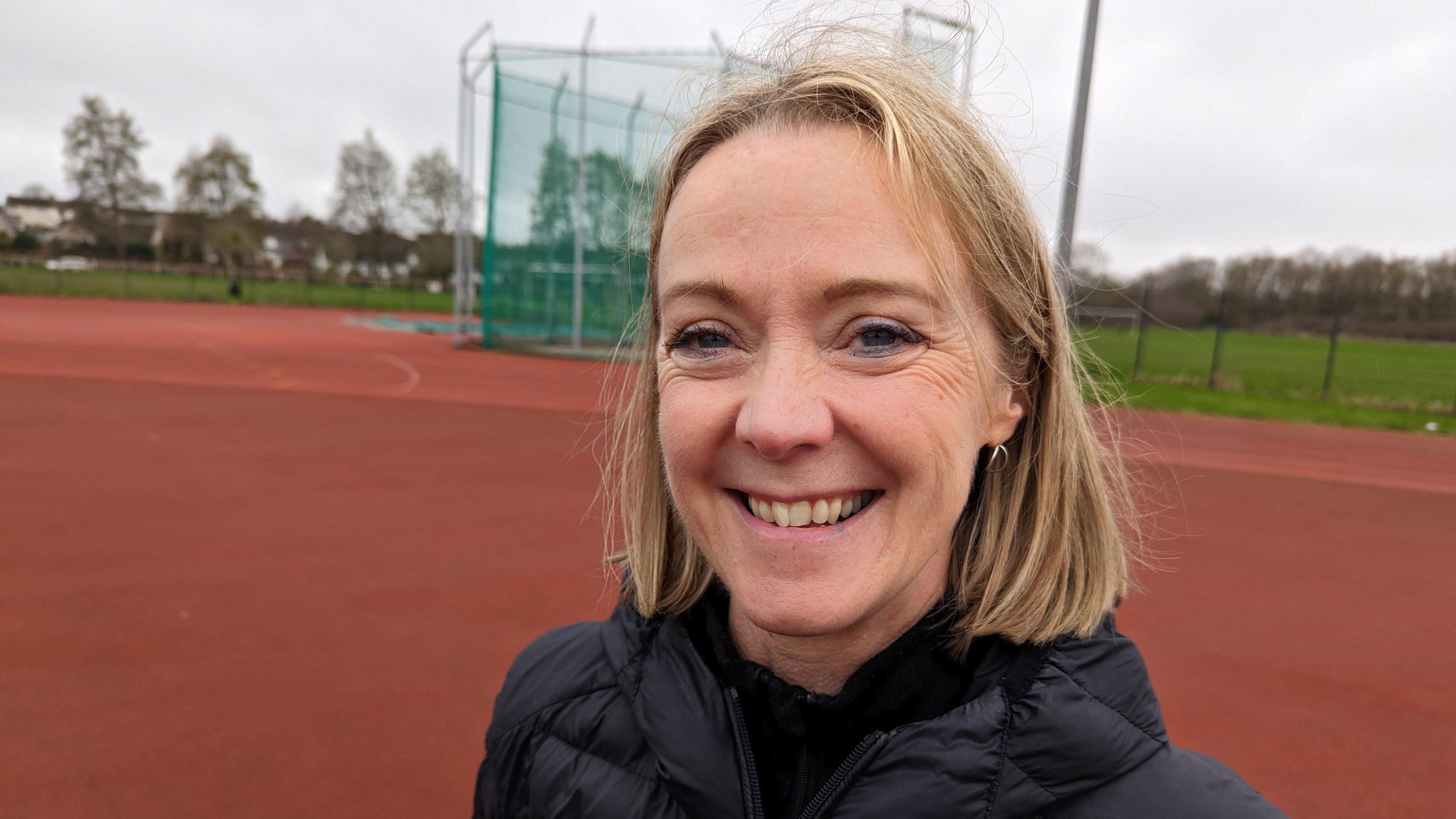 A woman smiles on the running track