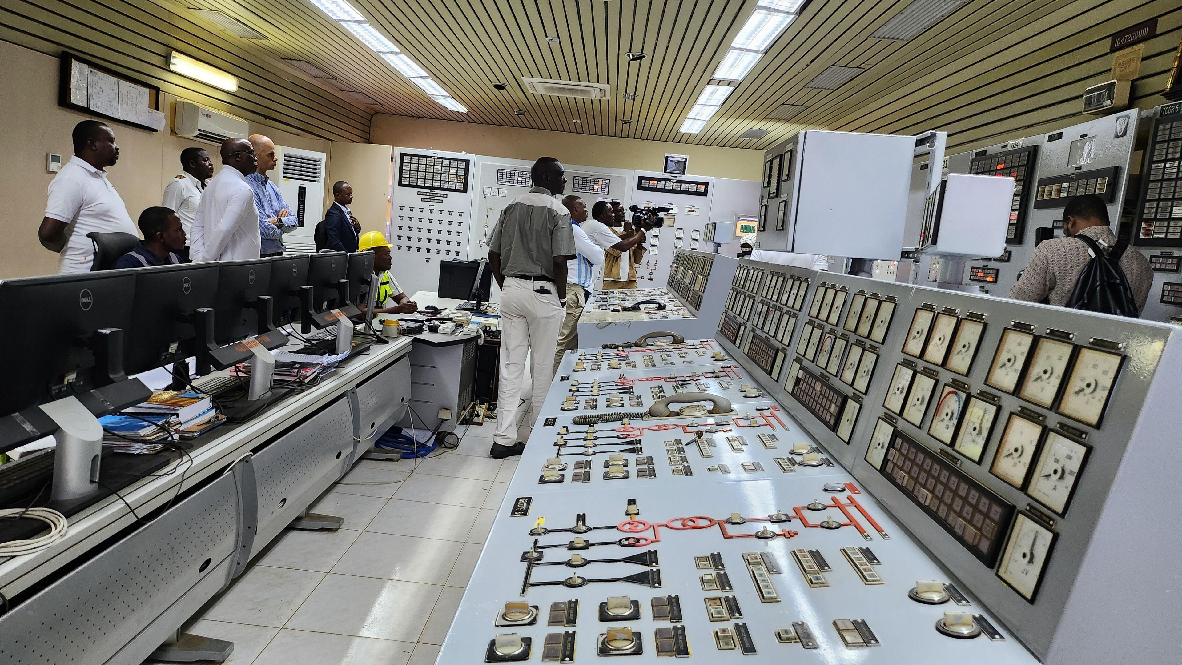 Workers stand in a control room for the existing Inga dams