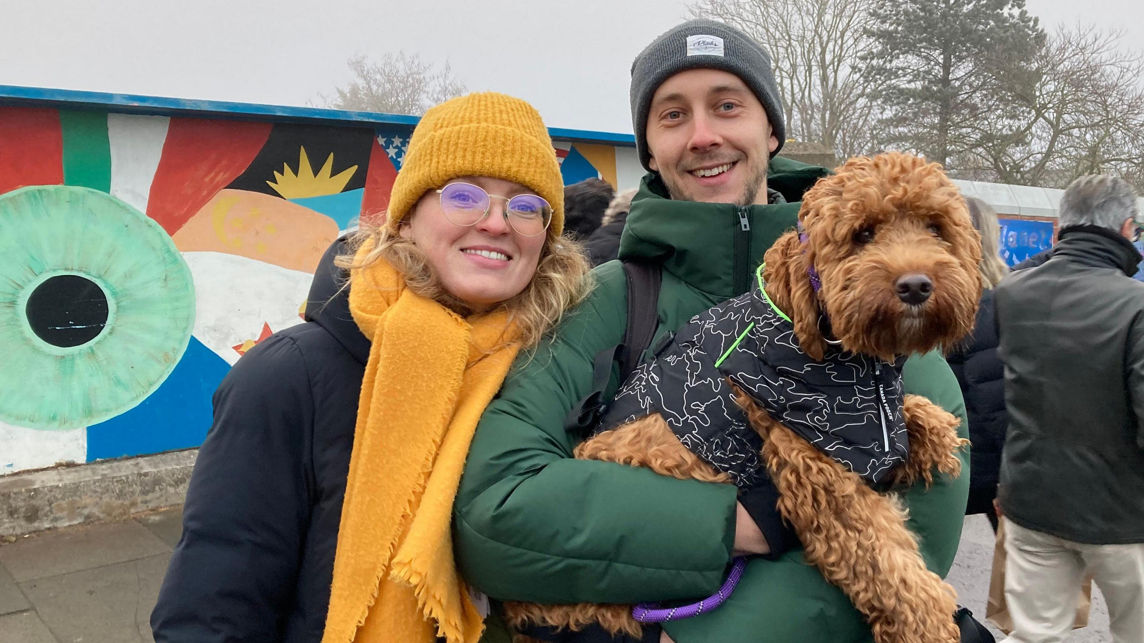 A man and woman holding a dog