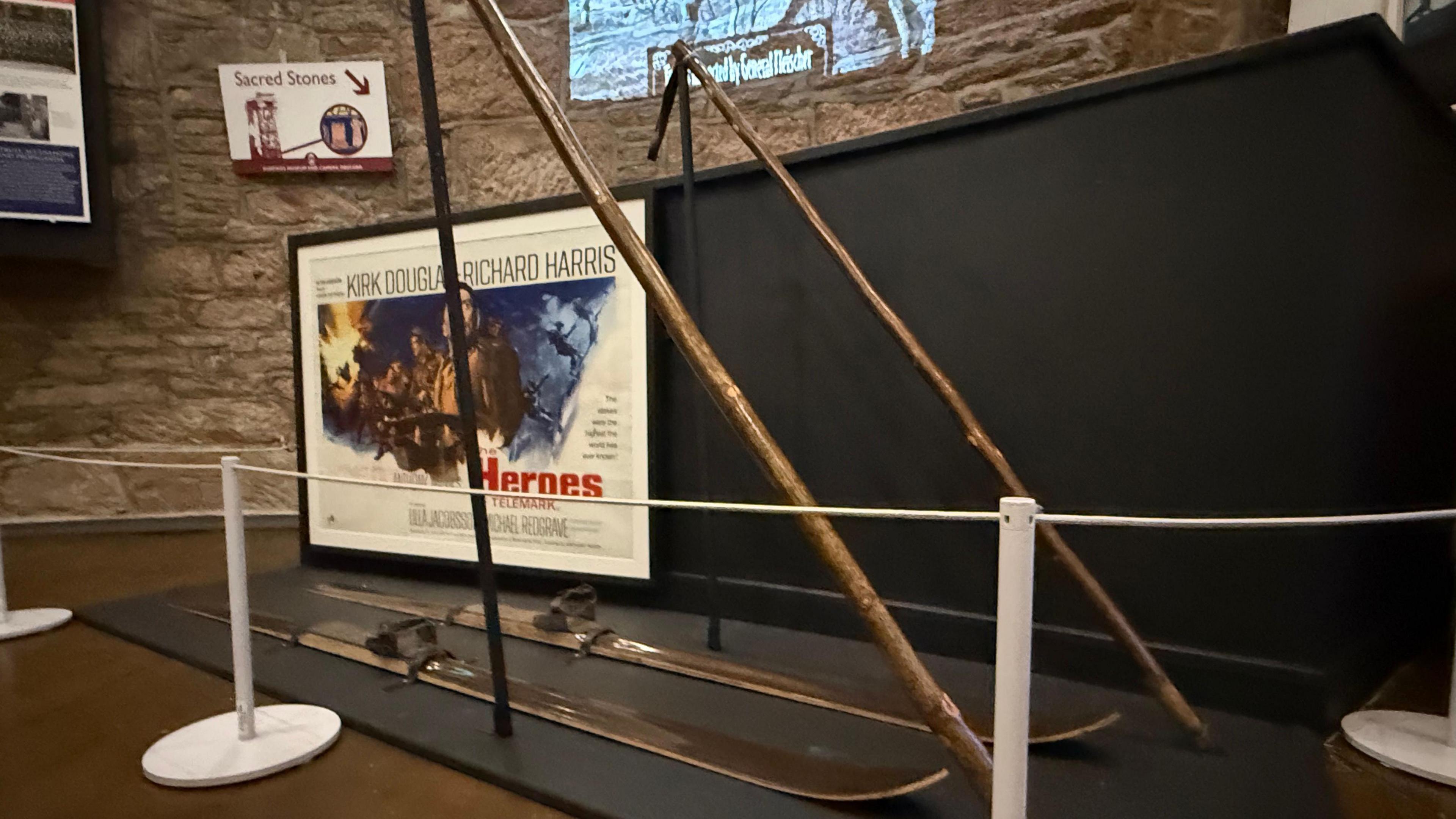 A set of wooden skiis in front of a vintage movie poster