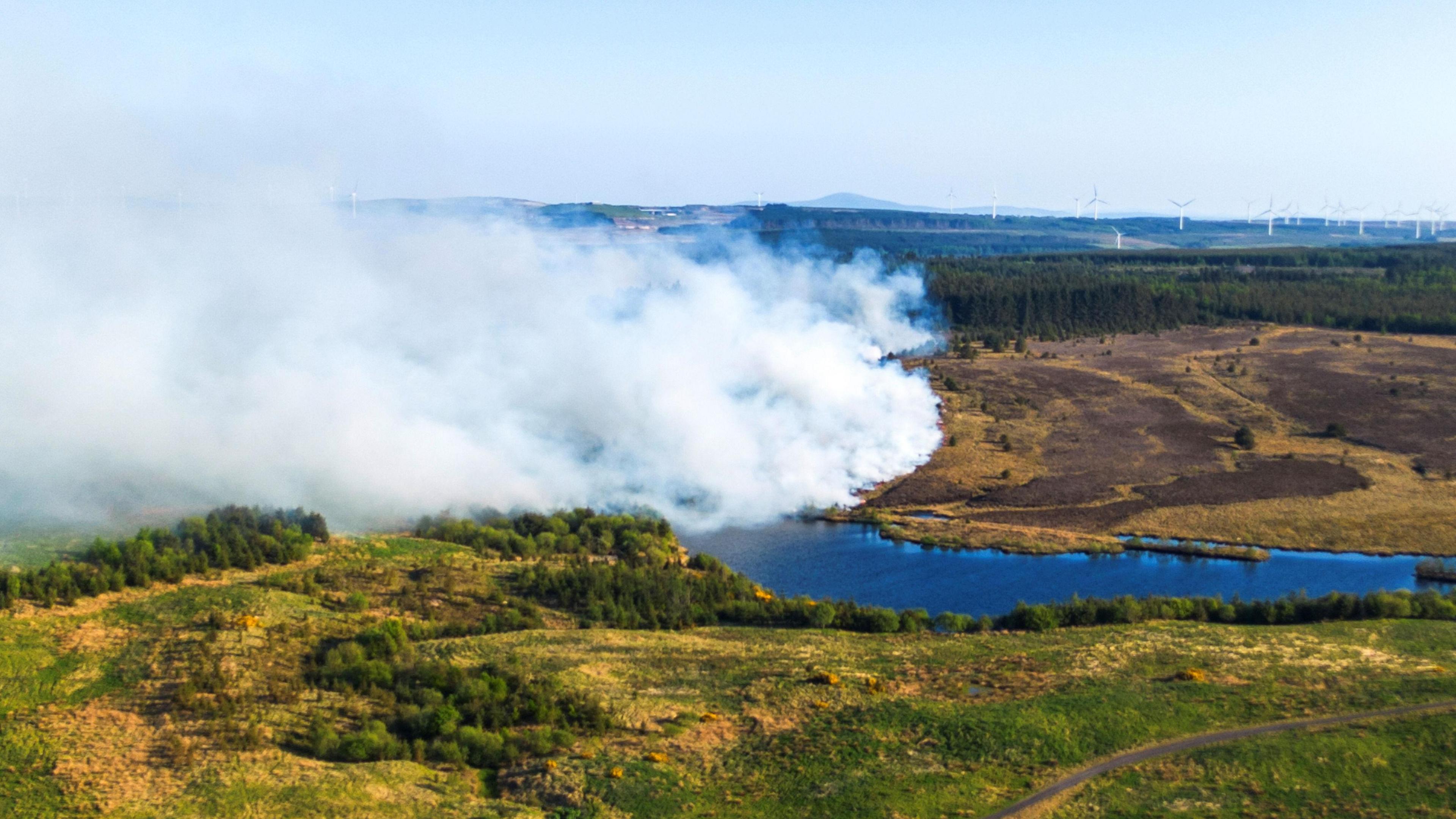 An aeriel view of the hills above Fauldhouse, with lots of smoke.