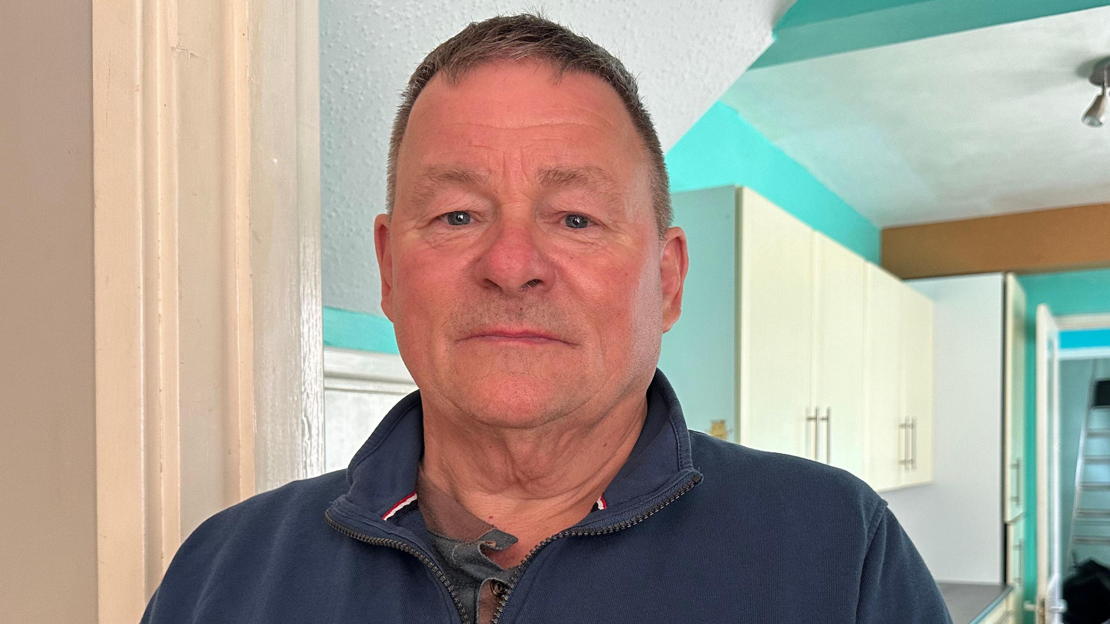 Head and shoulders picture of man in his kitchen