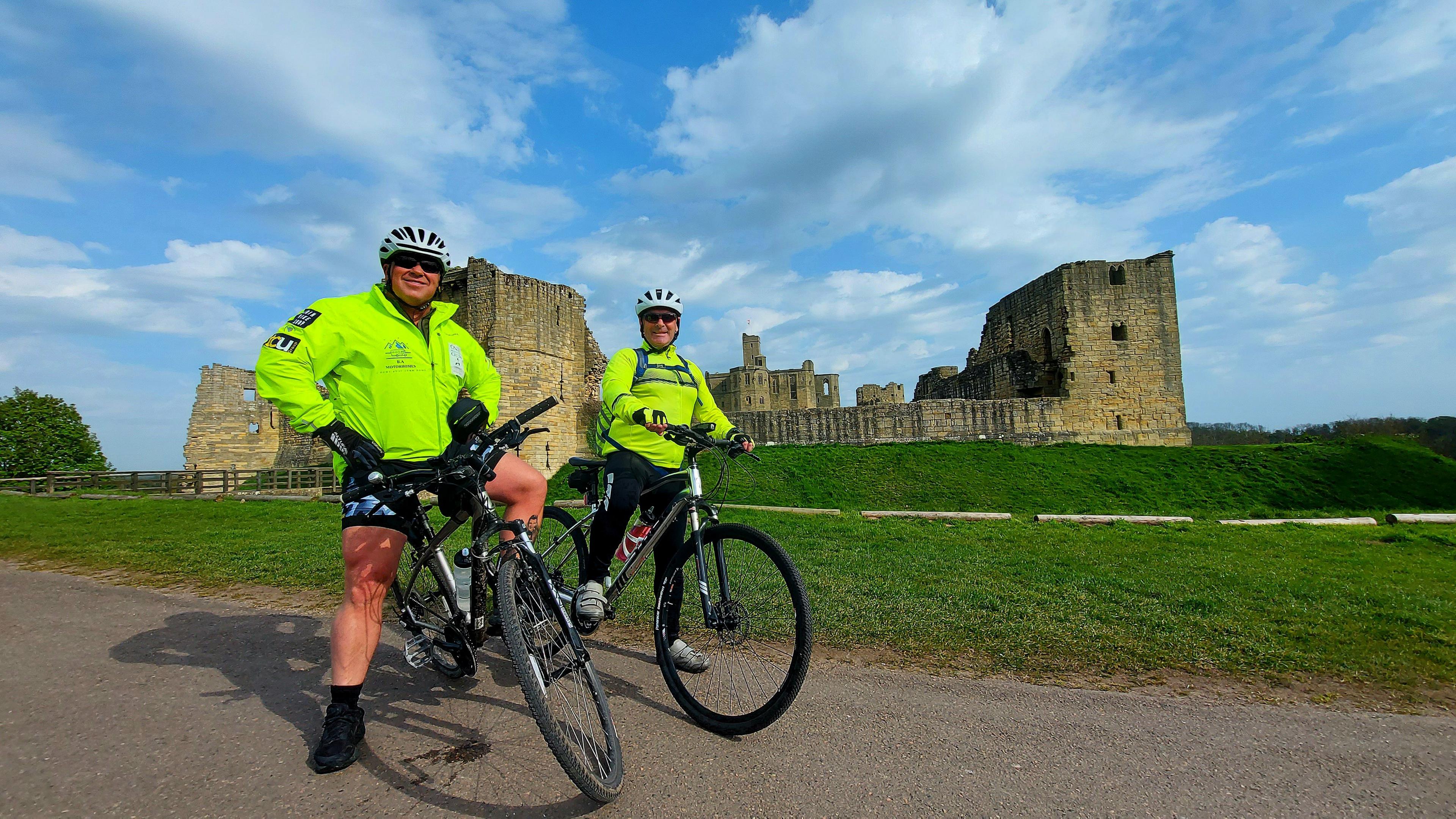 Jamie Bell and friend, Steve Charlton, posing on their bikes in front of Dunstonbrugh Castle