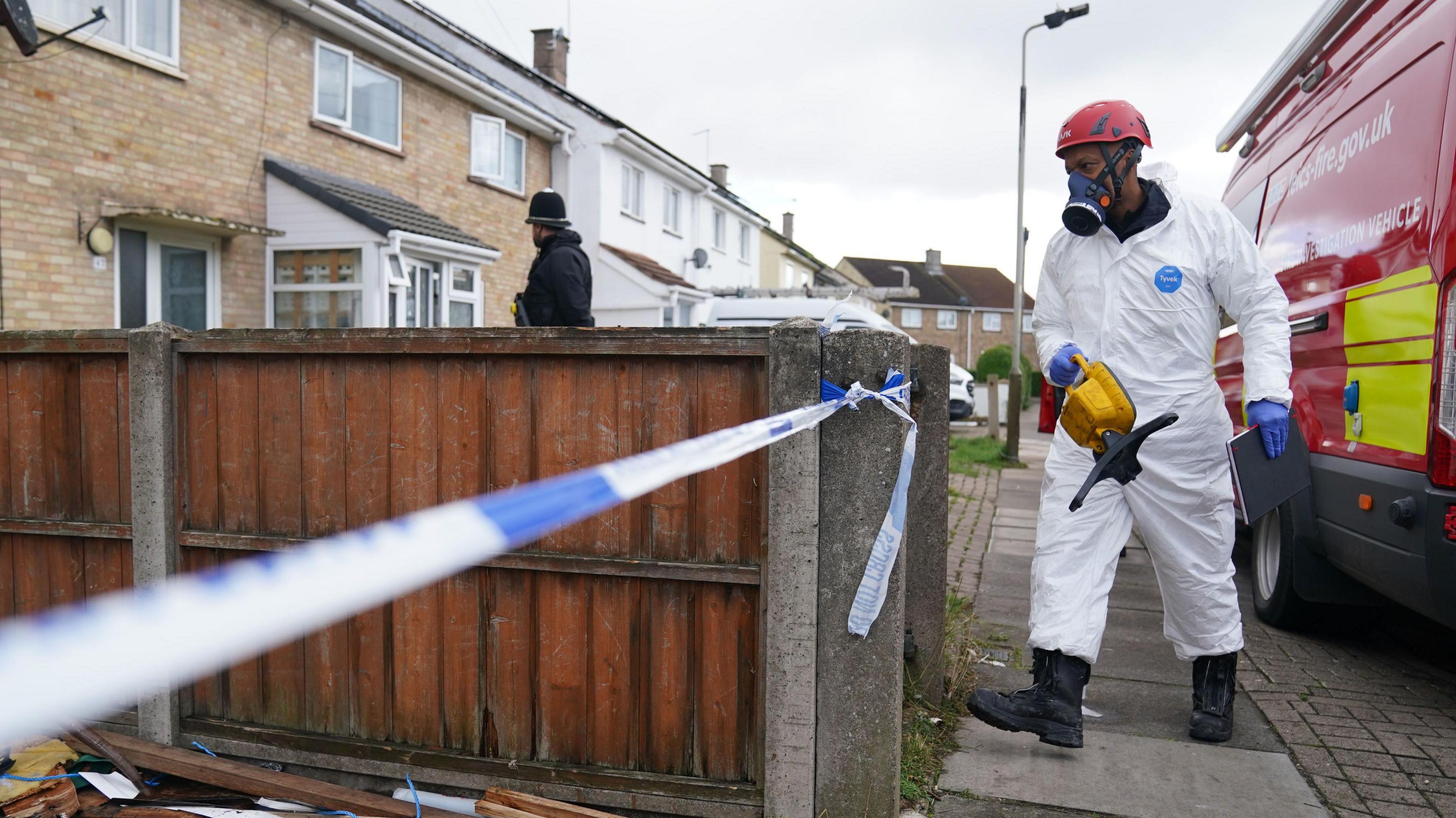 A firefighters wearing a protective suit and mask at the scene of the fire