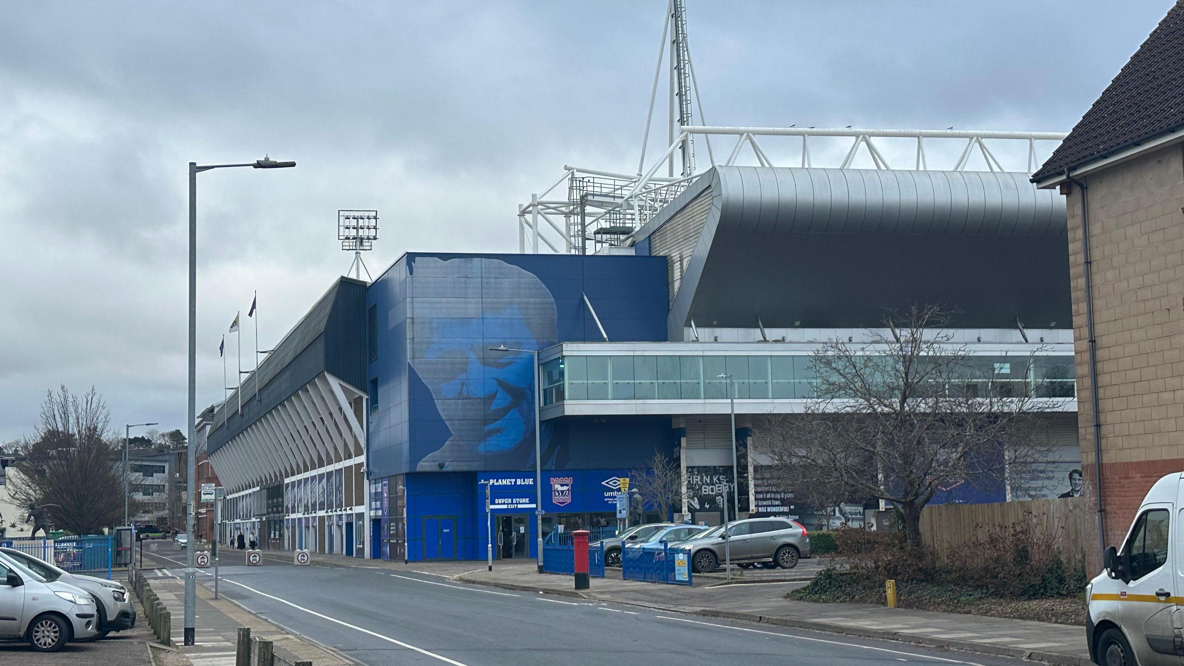 A general view of the outside of Portman Road Stadium. Cars can be seen parked outside the stadium.