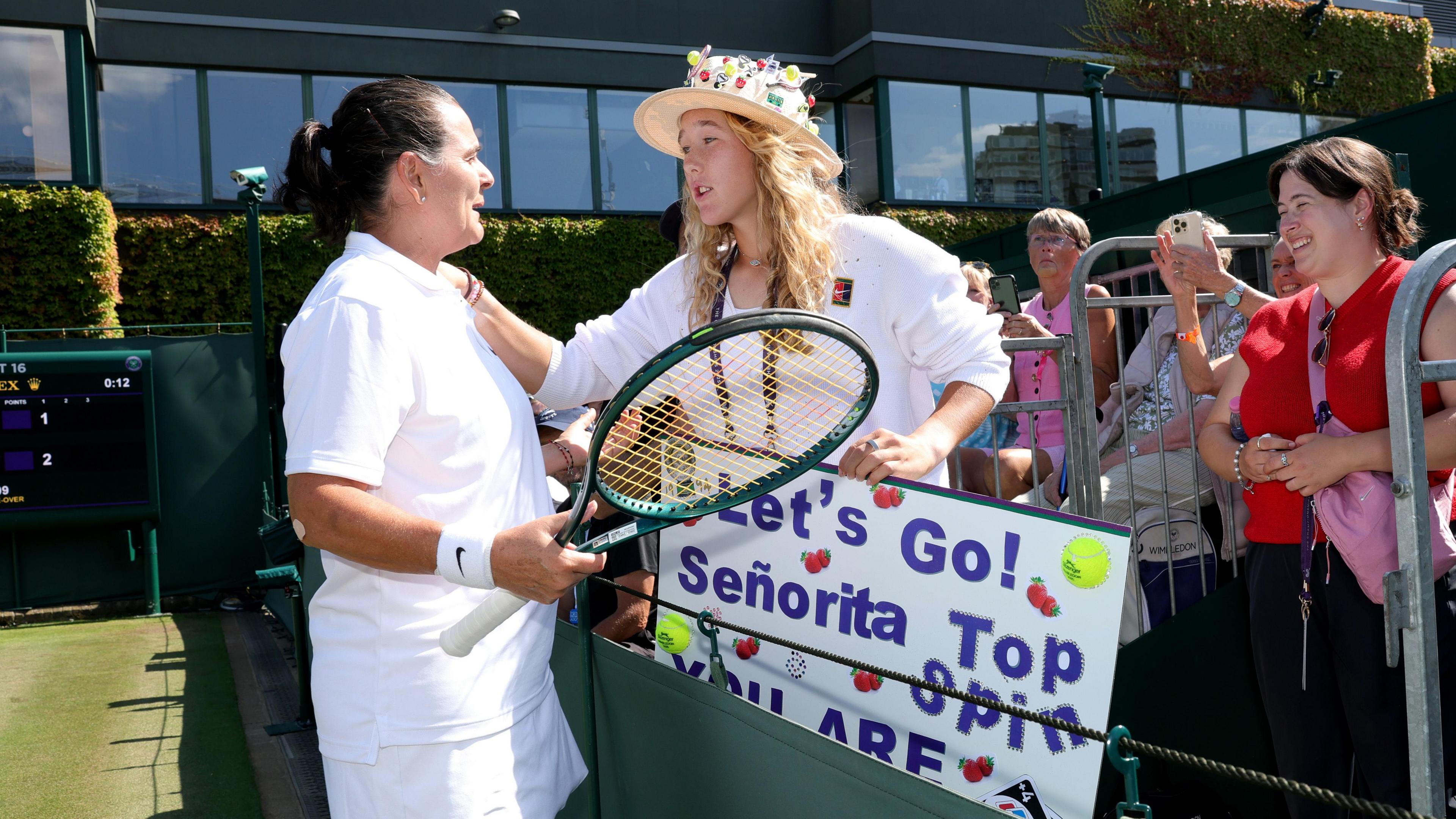 Mirra Andreeva and Conchita Martinez chat during her invitational doubles match on court 16 at Wimbledon