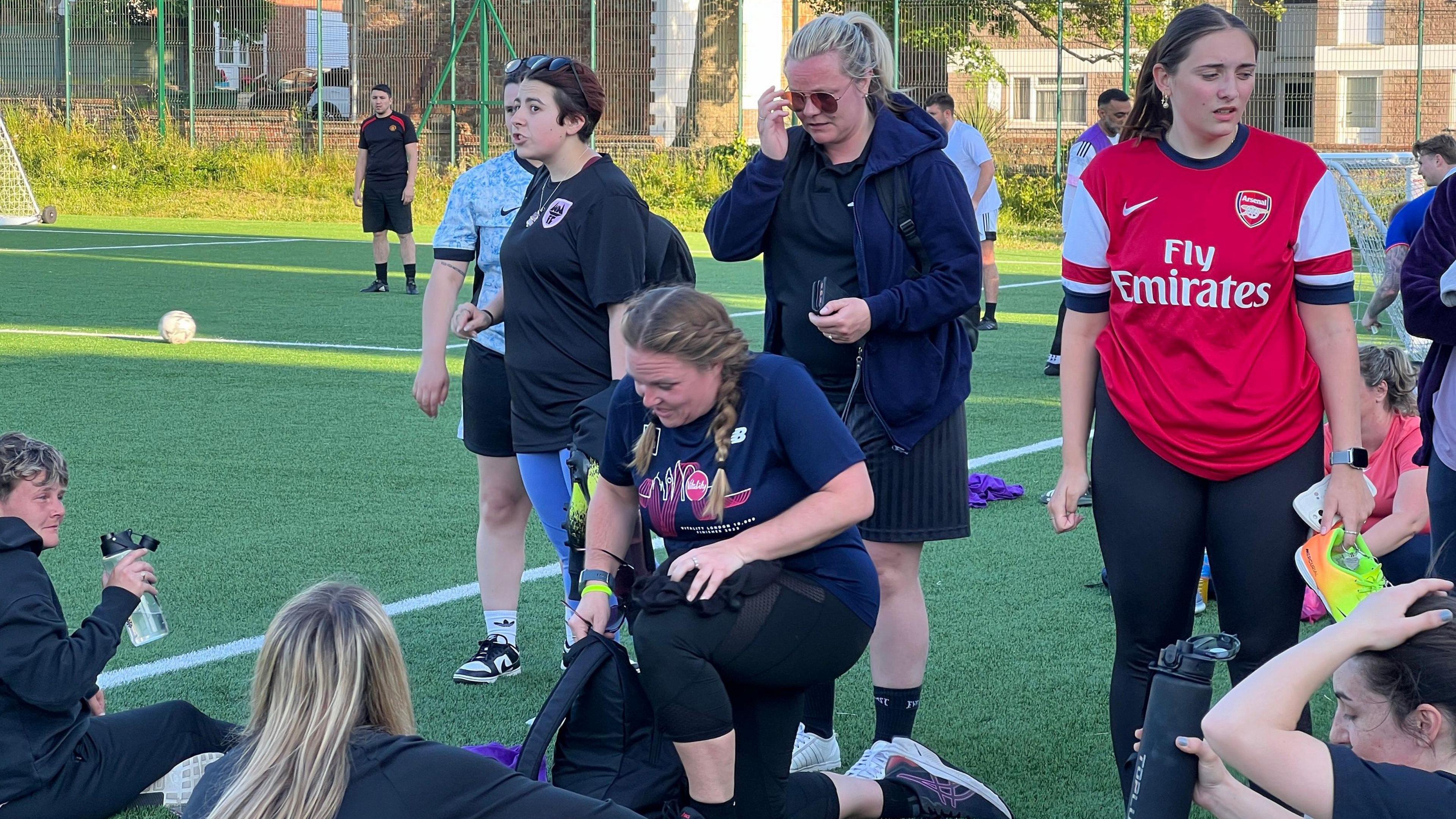 A group of women chat after finishing a football game