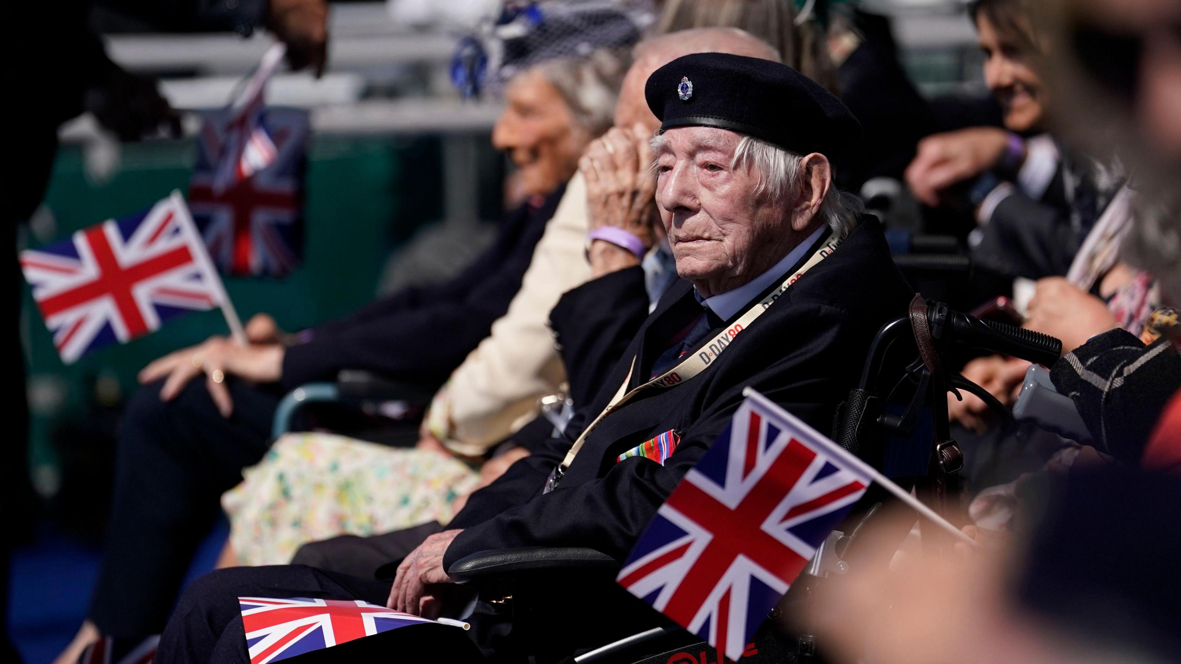 A Normandy veteran sat in a wheelchair attending the UK's national commemorative event for the 80th anniversary of D-Day