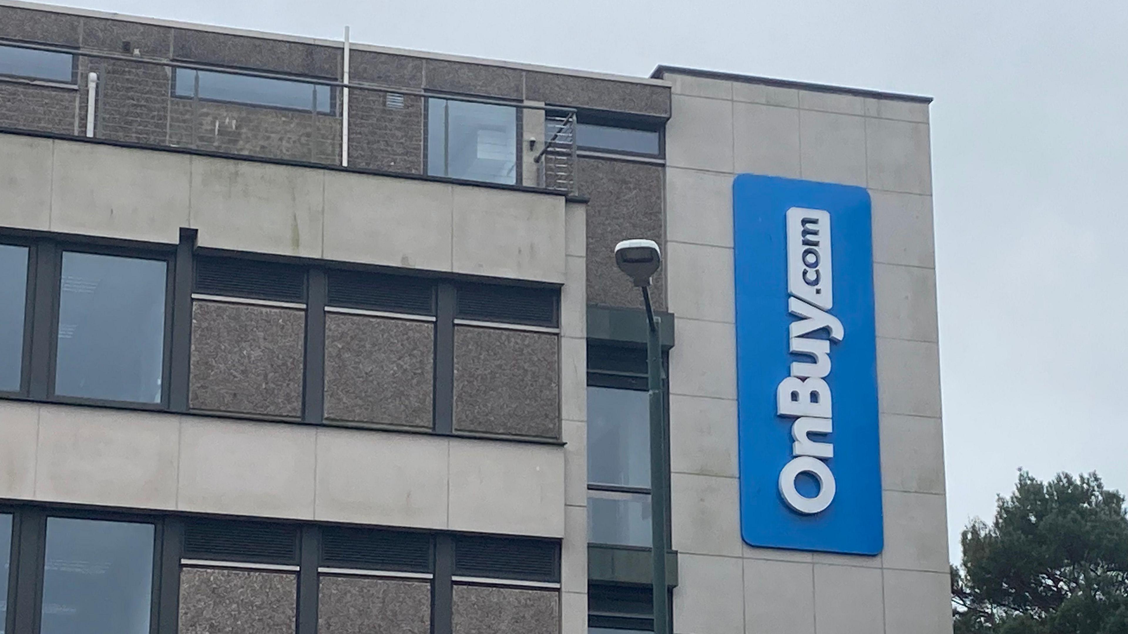 A five-storey office block with a blue OnBuy sign on the side