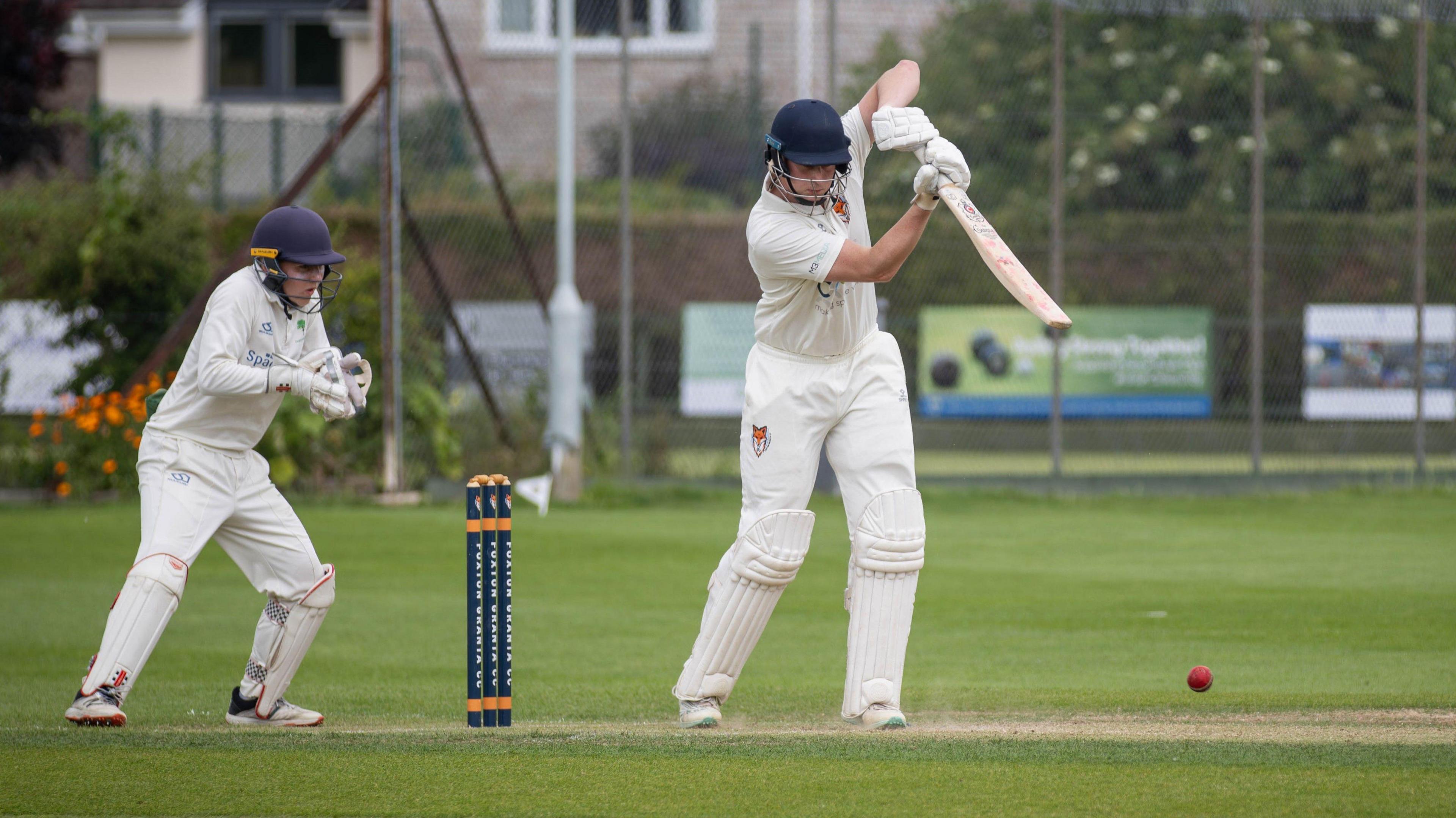 Wicketkeeper watching batsman play shot