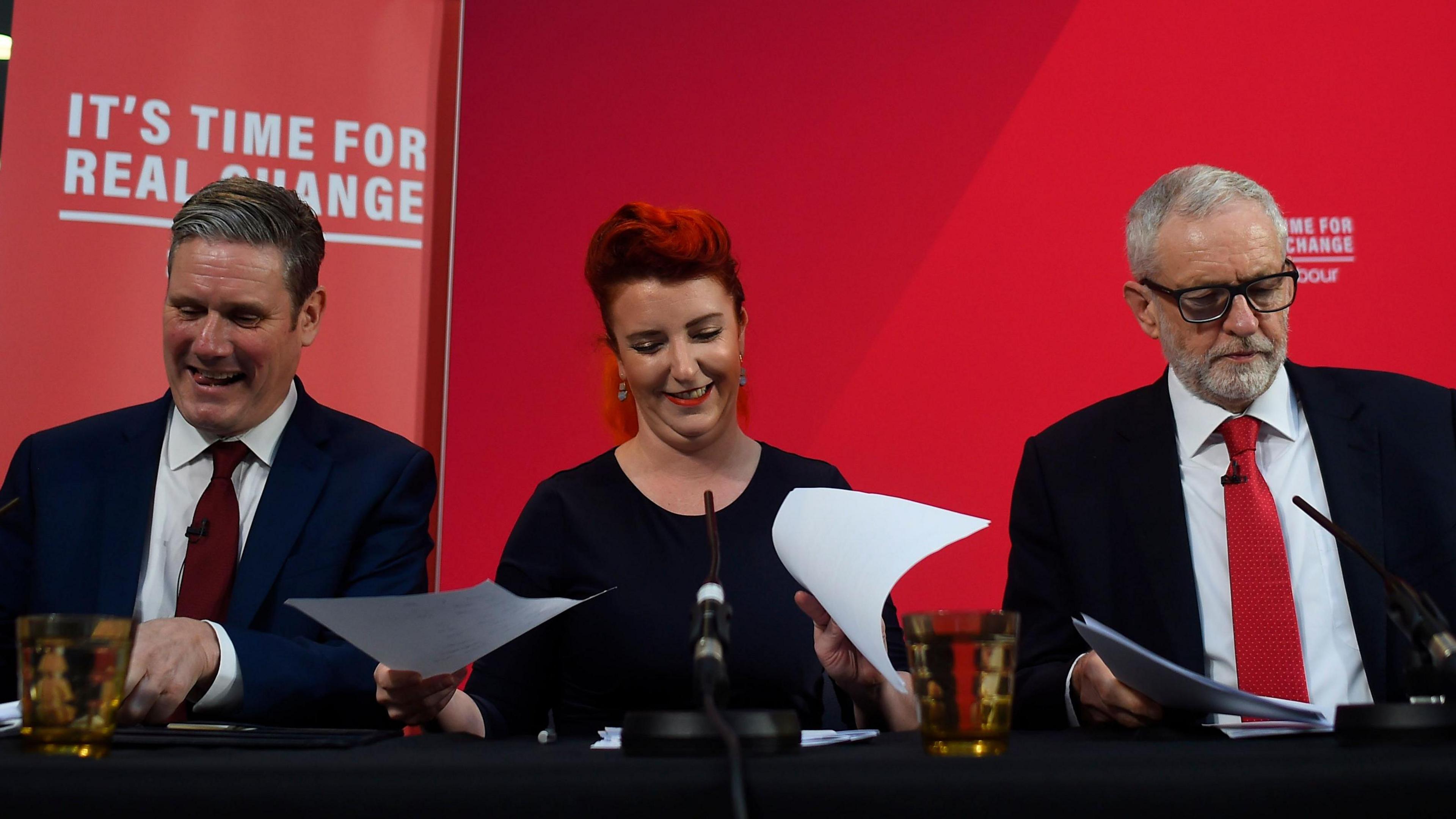 Louise Haigh pictured alongside Keir Starmer and Jeremy Corbyn behind a banner saying "It's time for real change"