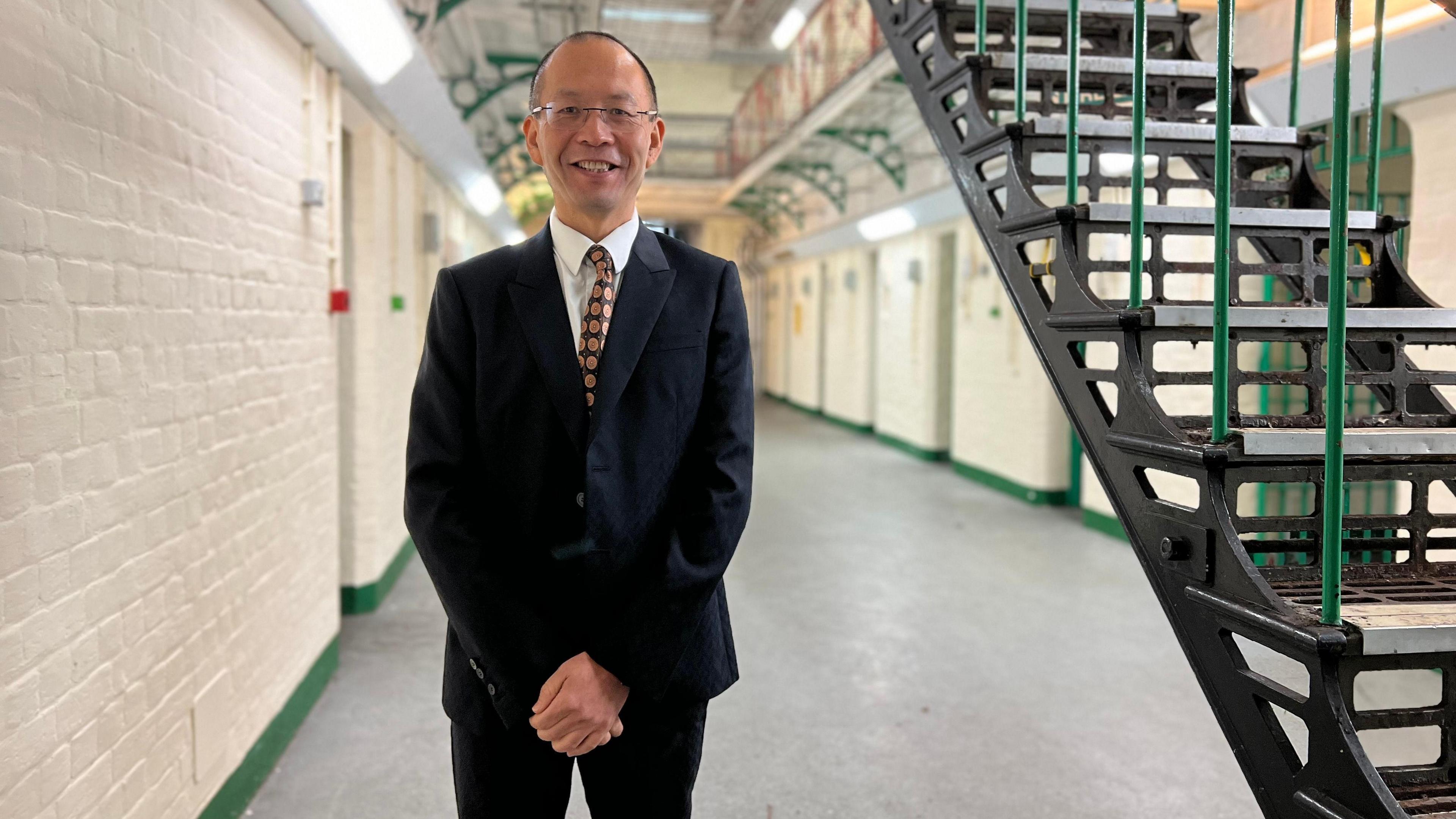 Channing Bi stood in a suit in the hall of the jail