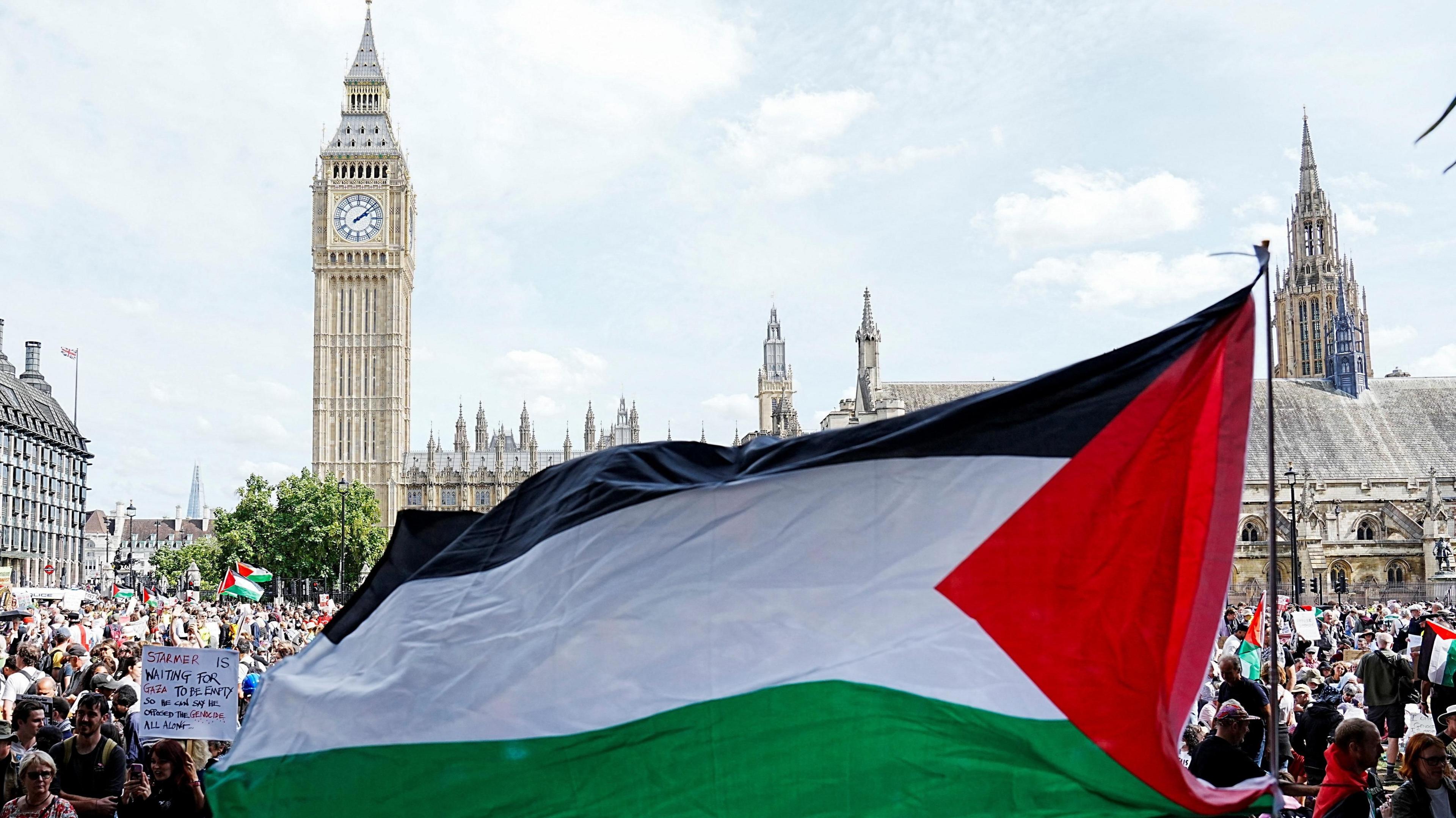 A Palestinian flag is flown by demonstrators at the Lift The Ban rally, challenging the British government's proscription of Palestine Action under anti-terrorism laws, in Parliament Square, London