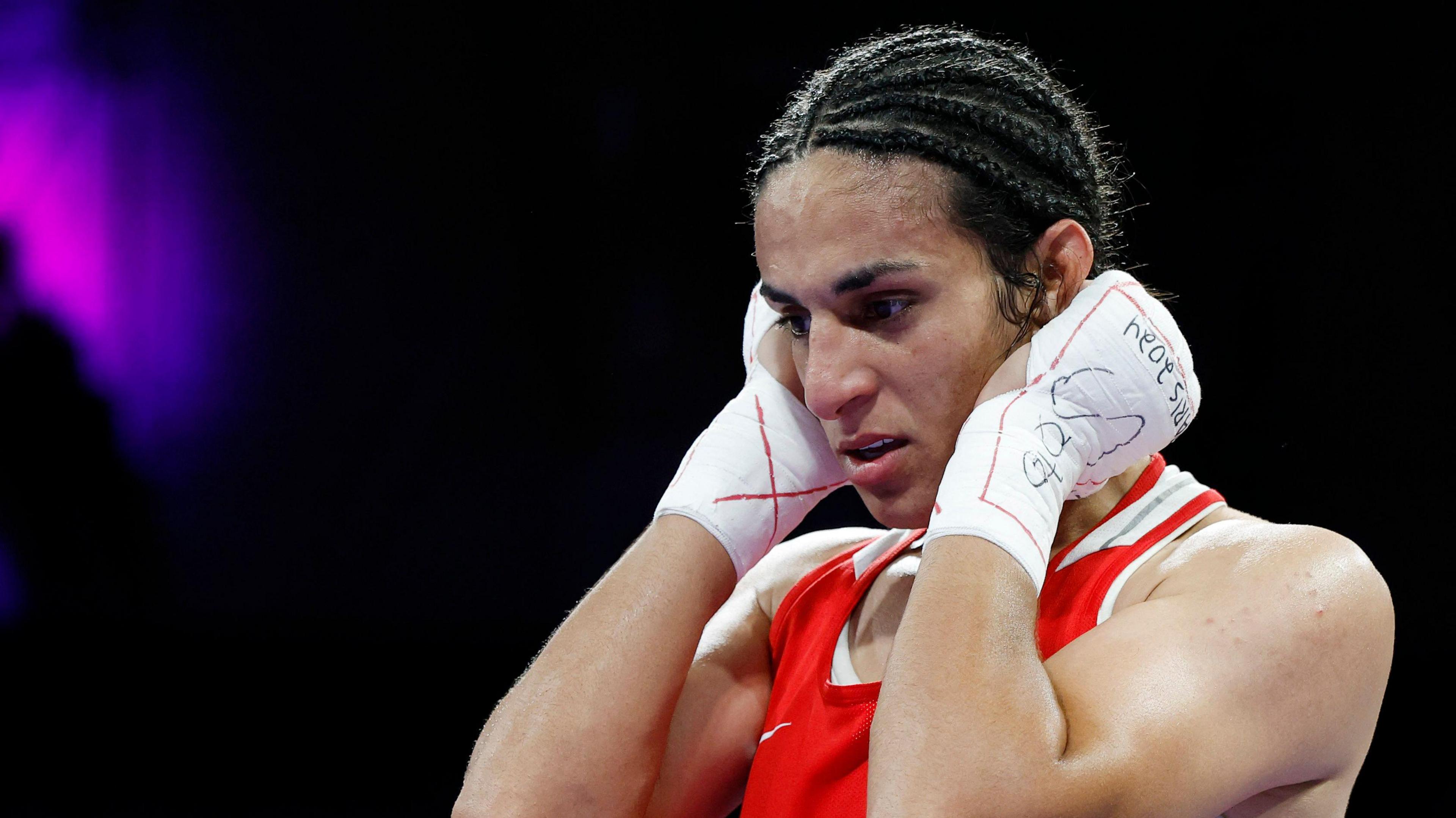 Imane Khelife wearing a boxing vest stares forward