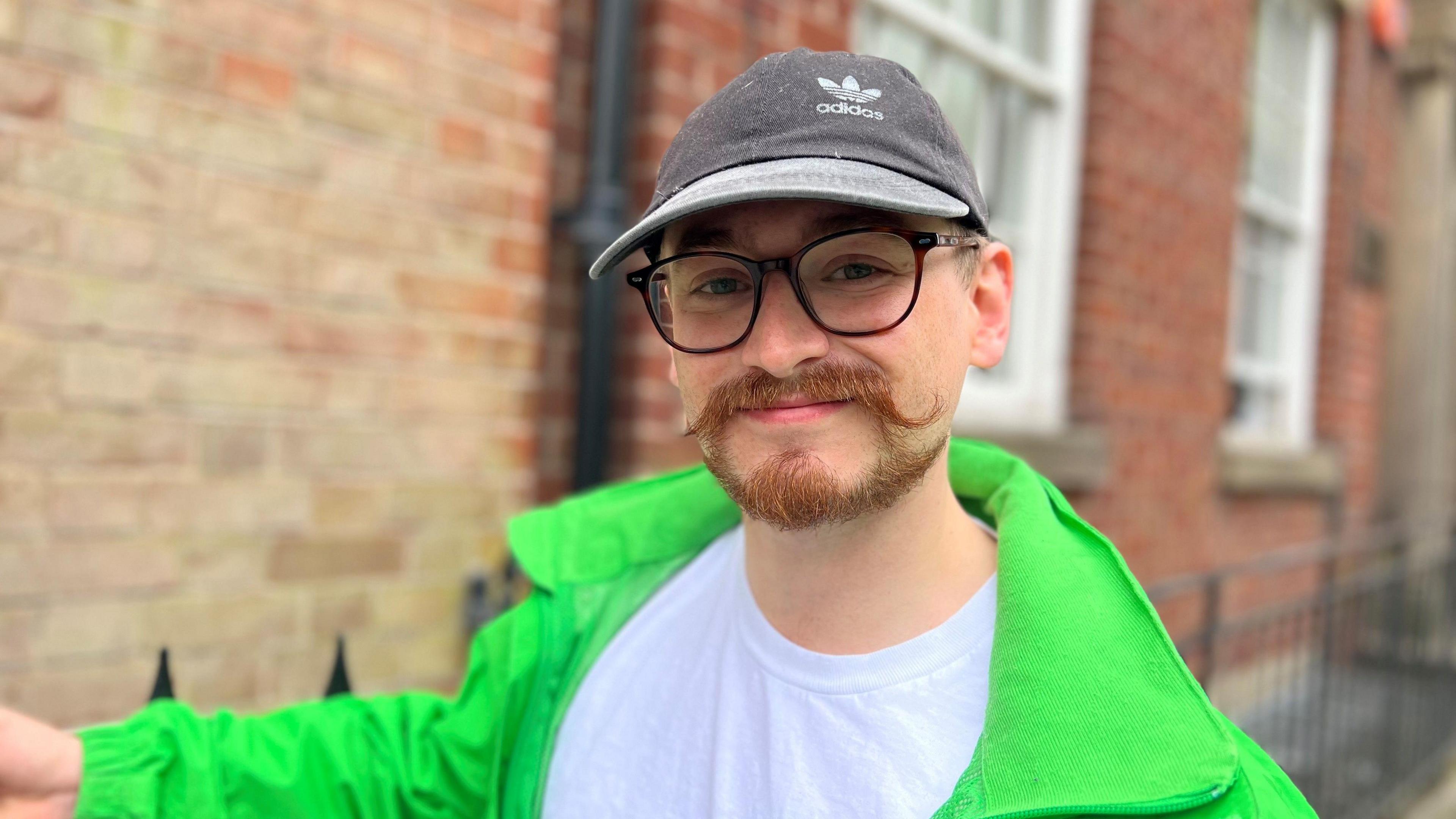 Jonny Cosmo smiling at the camera outside the house